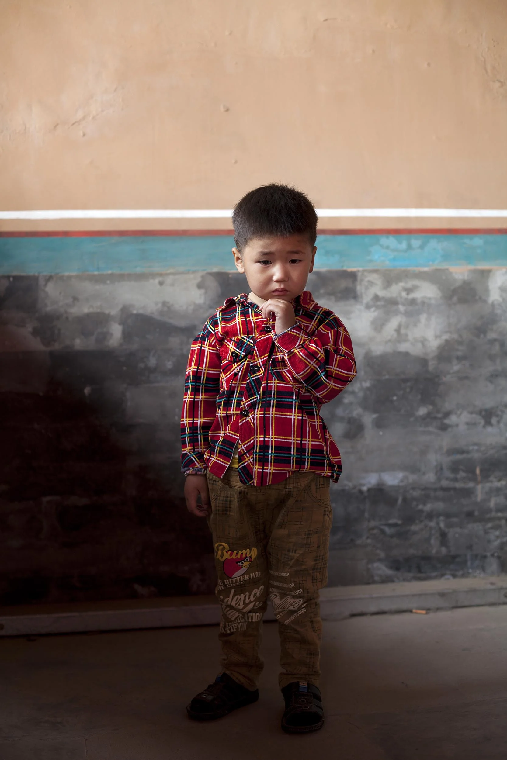 A portrait photograph of a young boy in the Forbidden City, Beijing , China Documentary photography part of a personal project