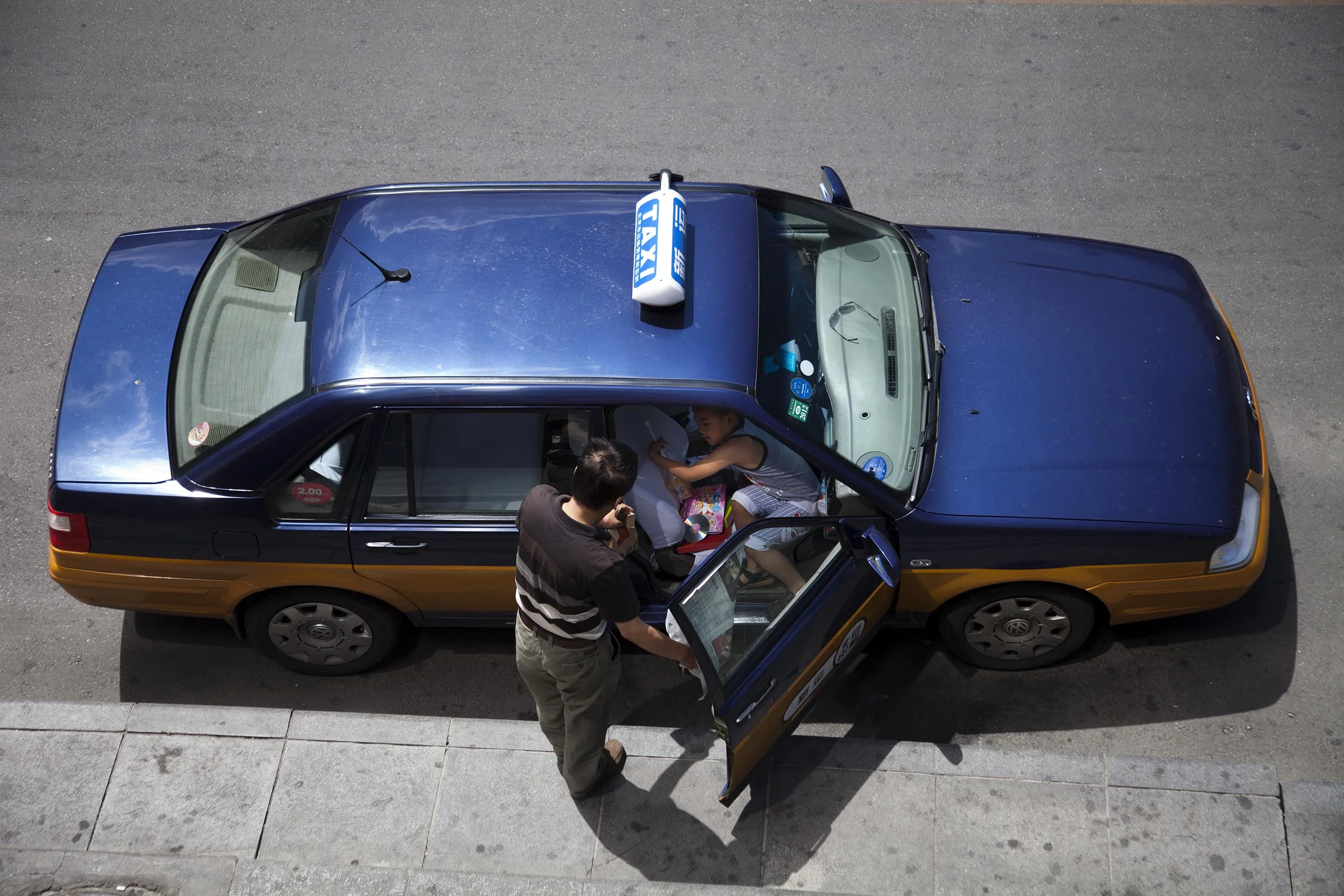 A photograph of people entering a taxi in Beijing, China Photography for Beijing Government