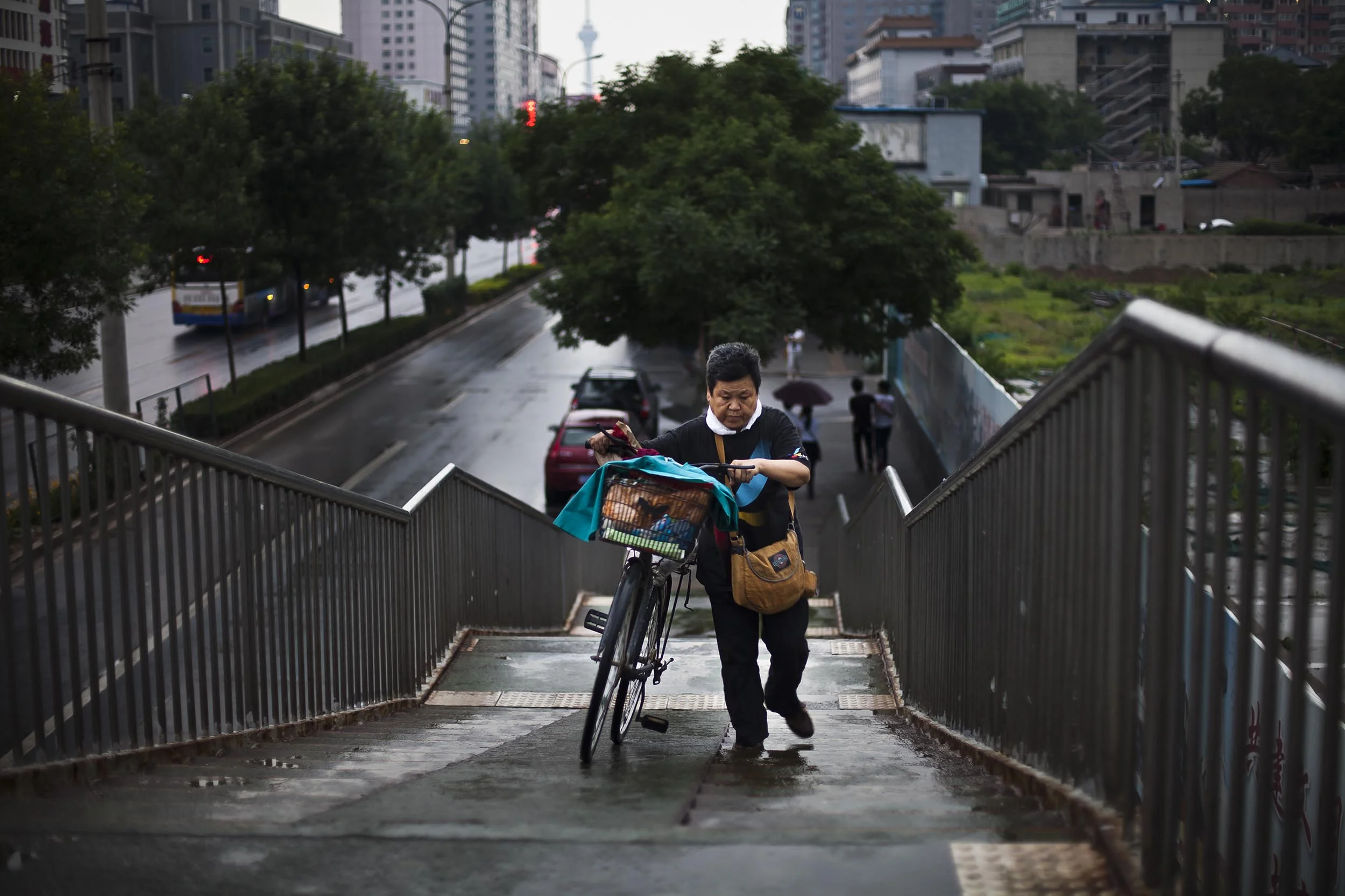  A photograph of a woman pushing bicycle up stairs in Beijing, China  Photography for Beijing Government 