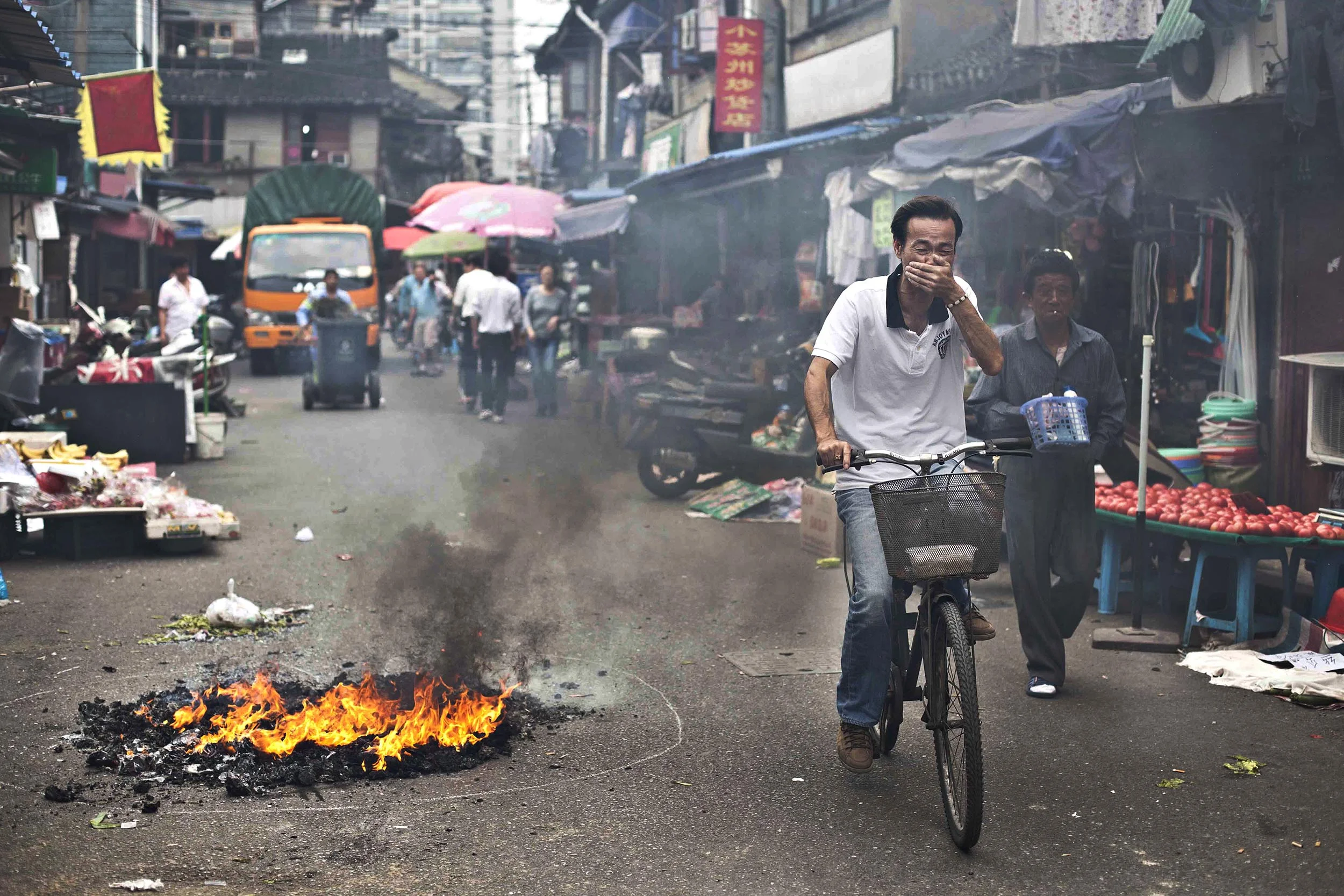  A photograph of cycling past burning rubbish in Shanghai, China  Photography for personal project 