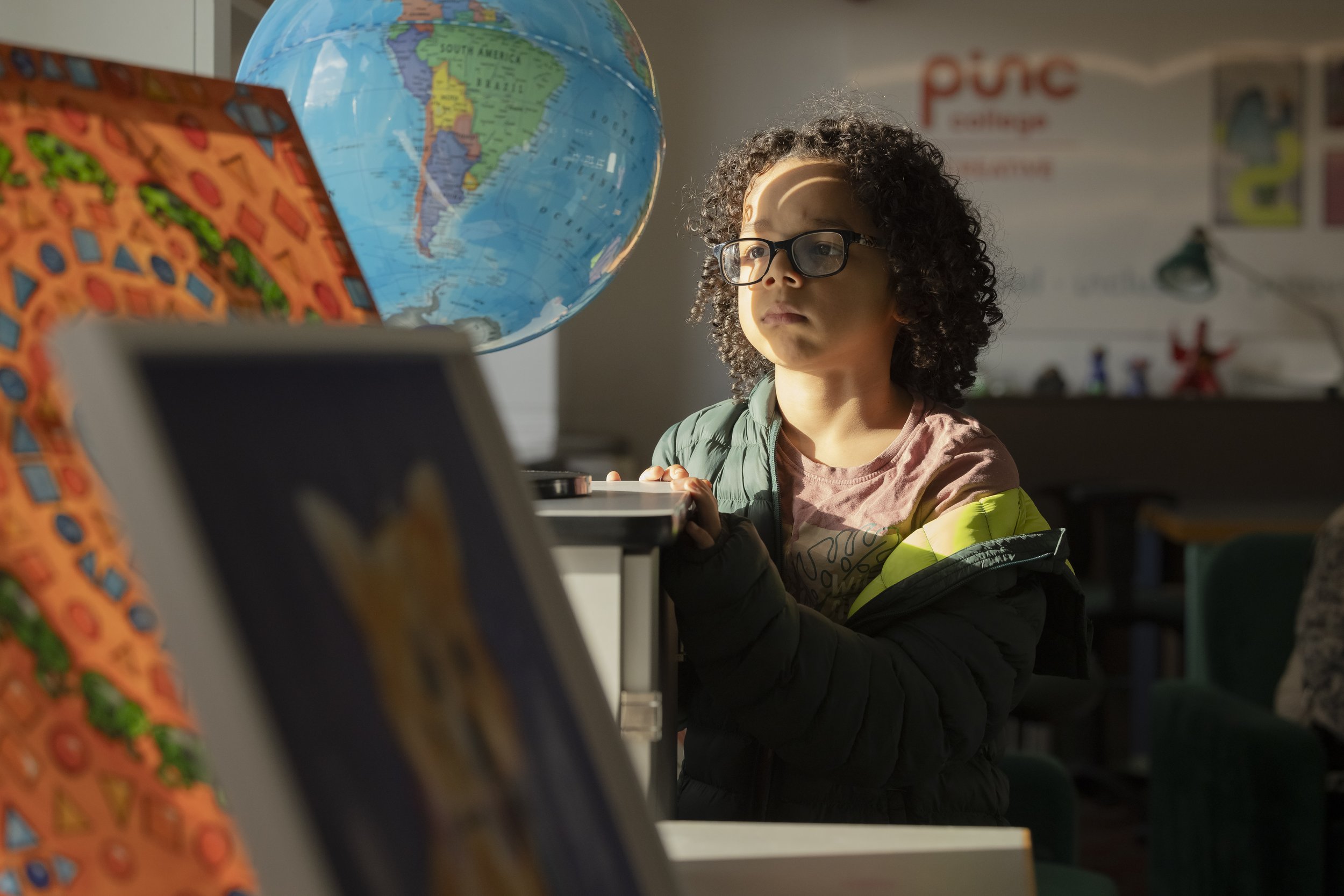 Young boy looking at a globe during a public event at Manchester Museum. 