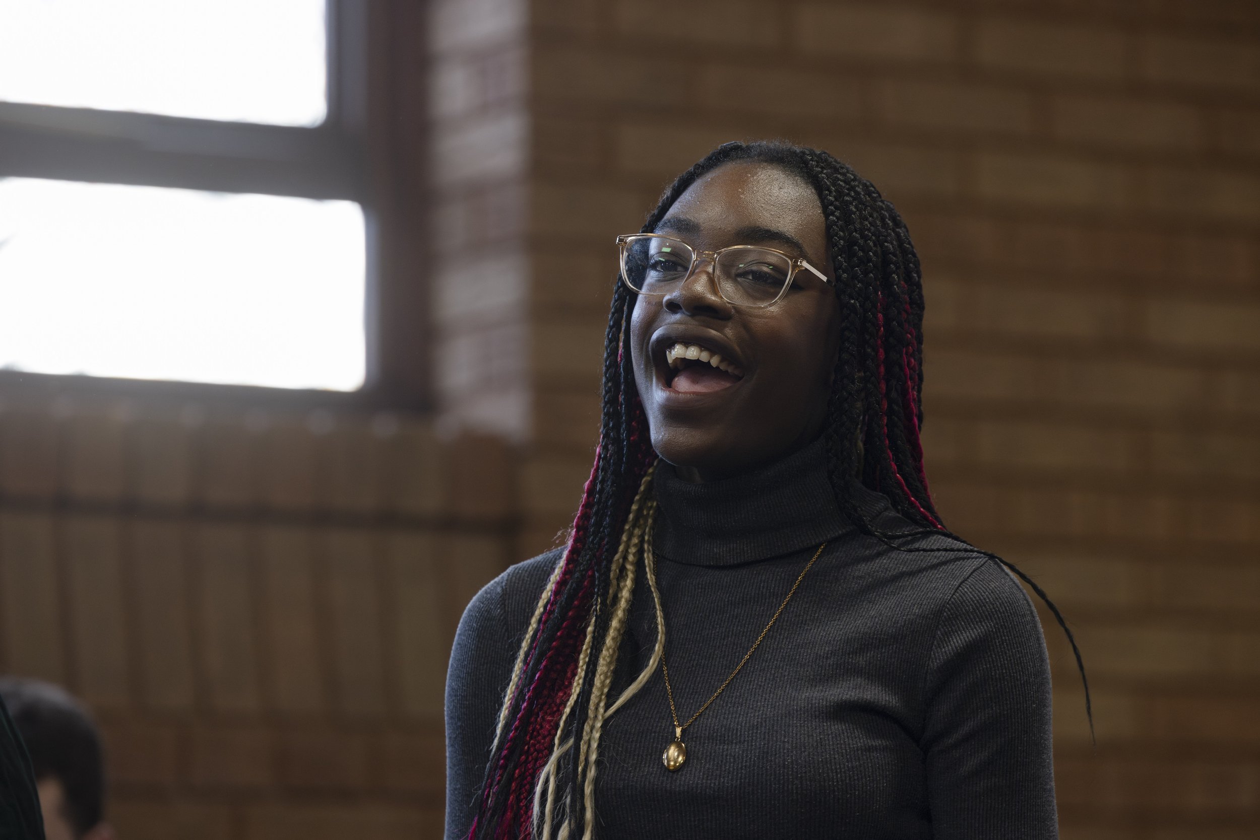  Young woman singing during Olympias Music Foundation performance in Manchester – documentary photography by David Oates 