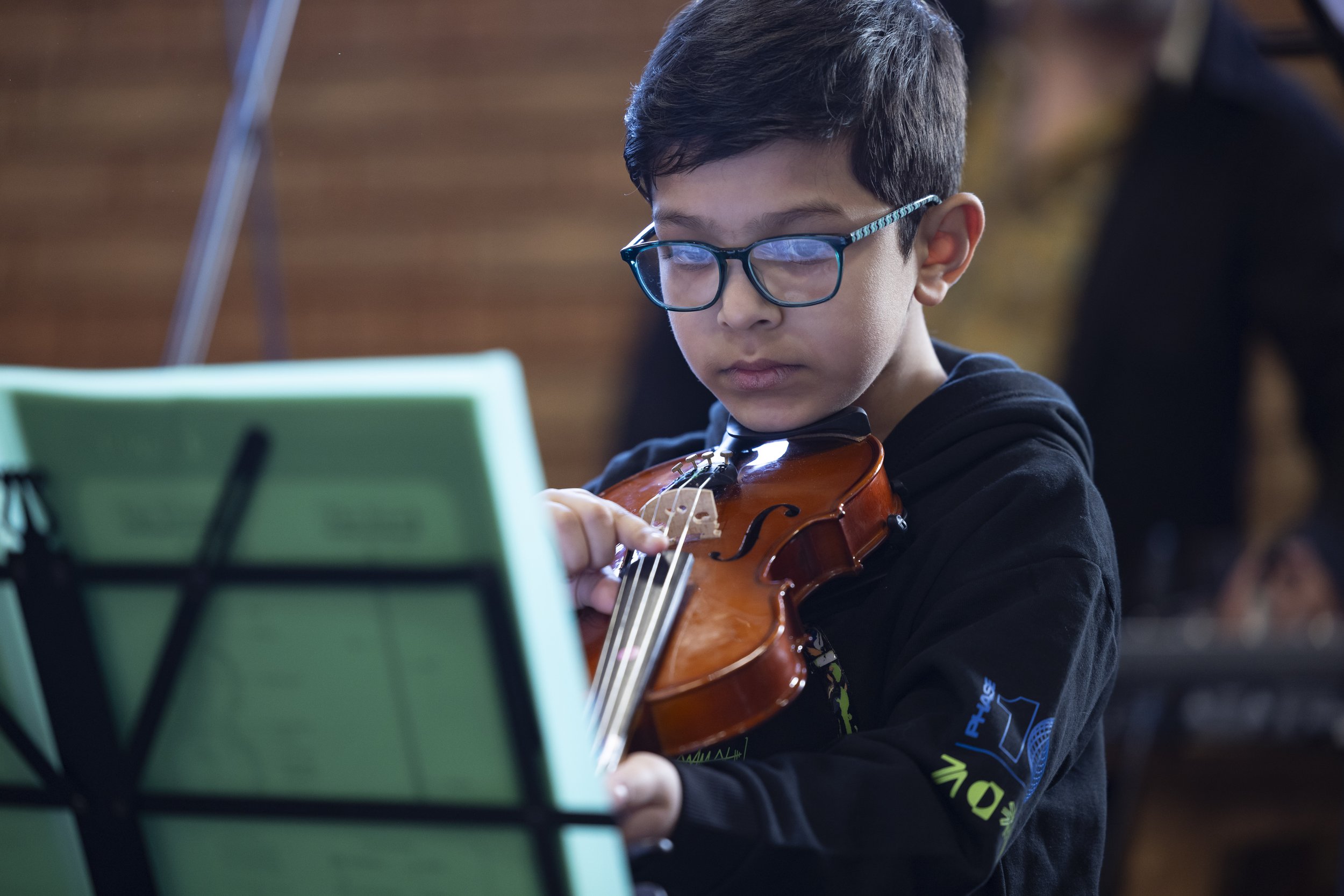  Young boy performing on violin at Olympias Music Foundation concert in Manchester – documentary photography by David Oates 