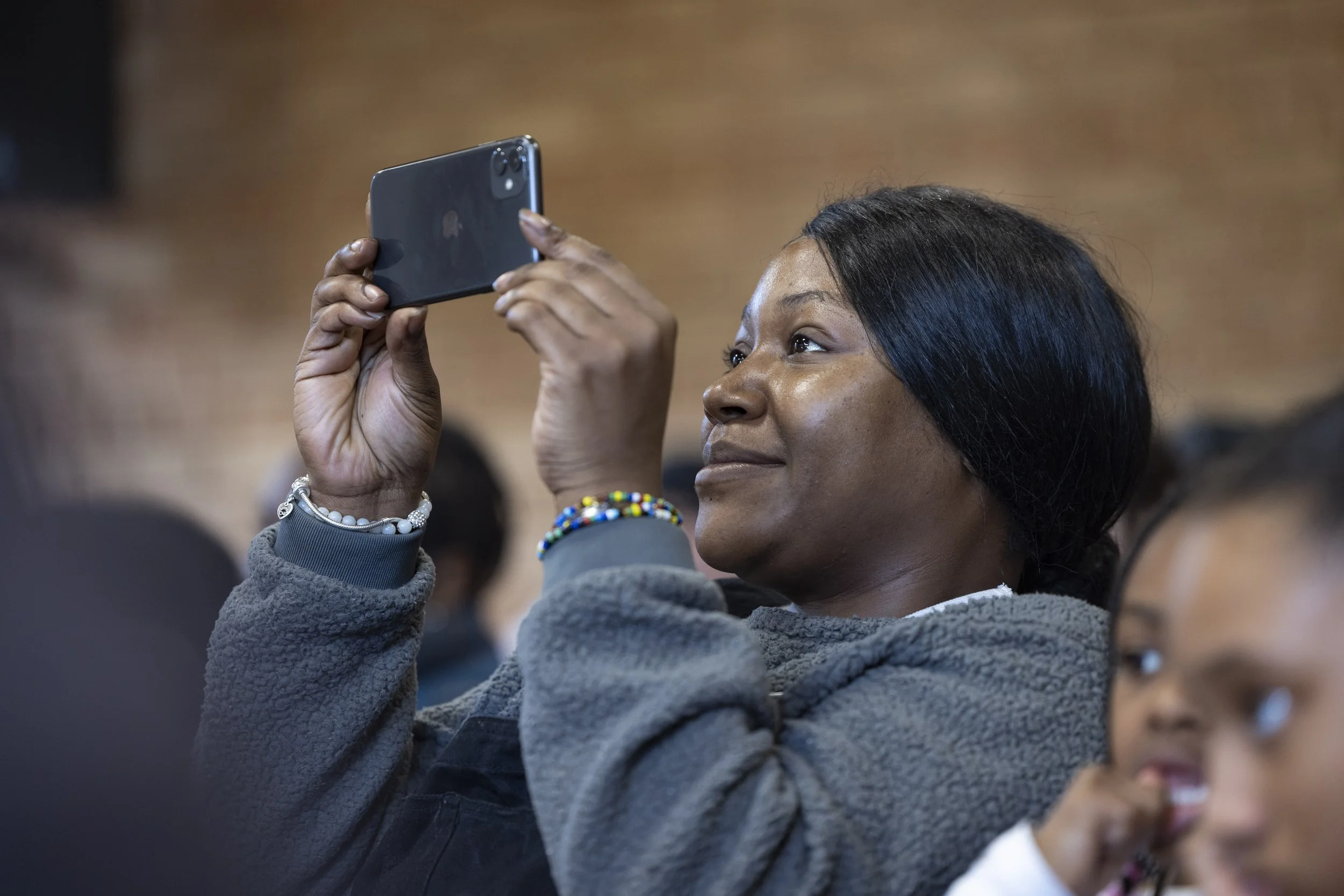 Mother photographing her child while they perform on stage during a live event.
