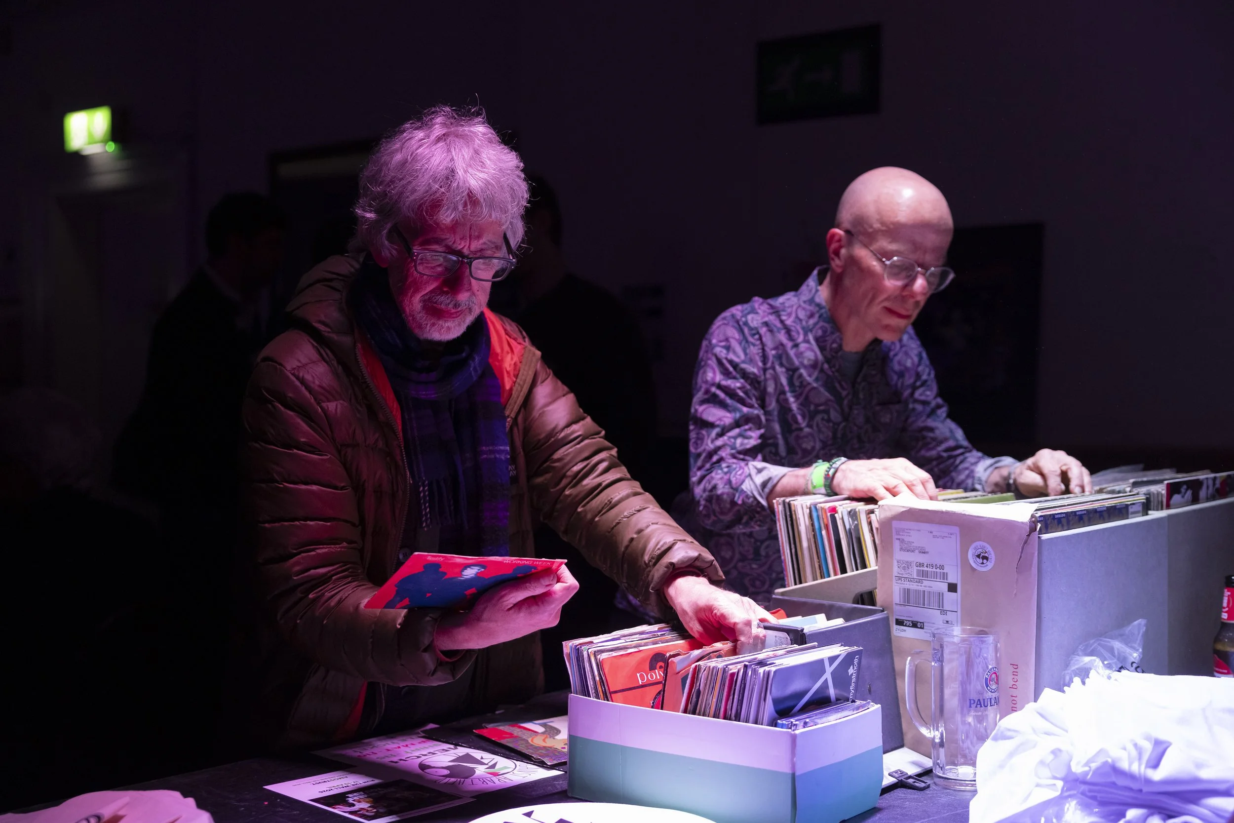 Two men browsing seven inch and twelve inch vinyl records at Manchester record fundraising event