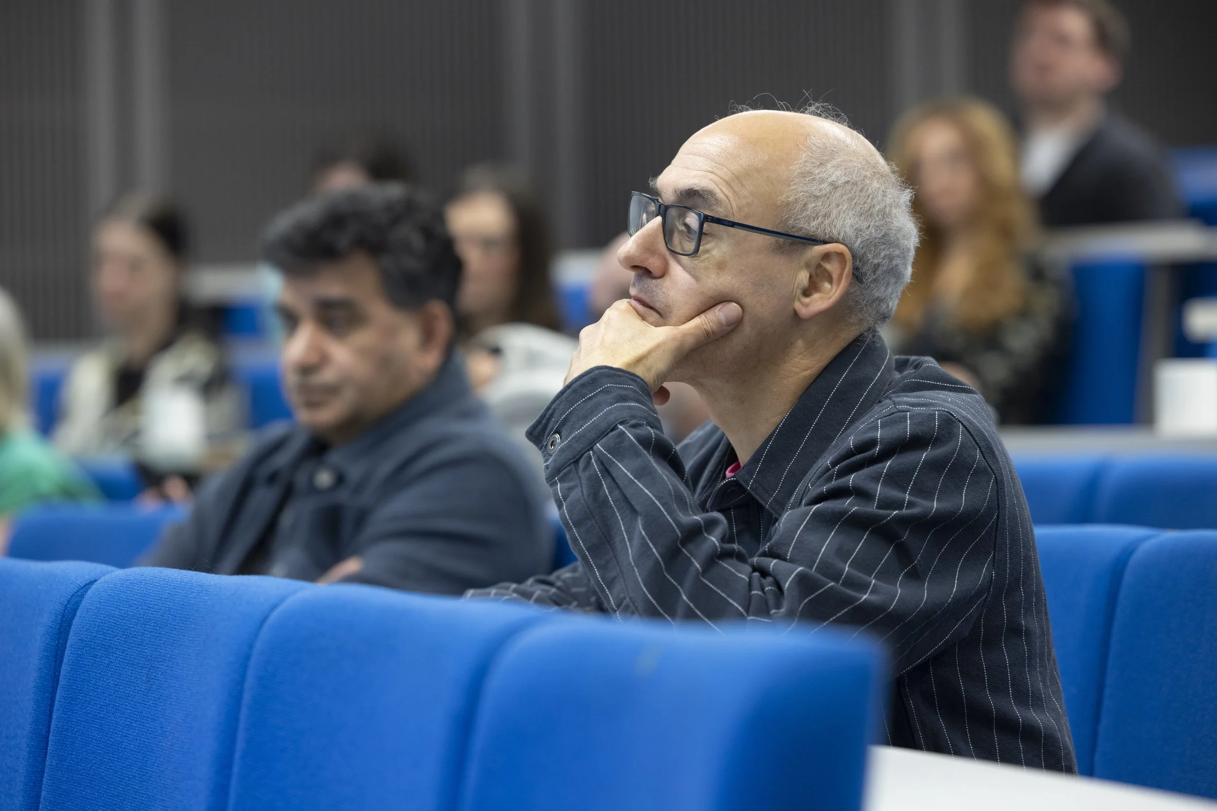 A man watching a presentation at a conference in Manchester