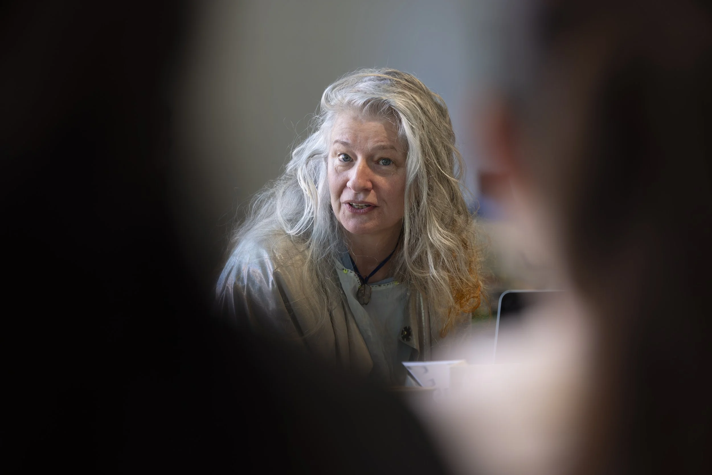 Close-up of Delaine Le Bas speaking with workshop participants during an upcycling and textile art session at The Whitworth, Manchester, focused on collaborative making