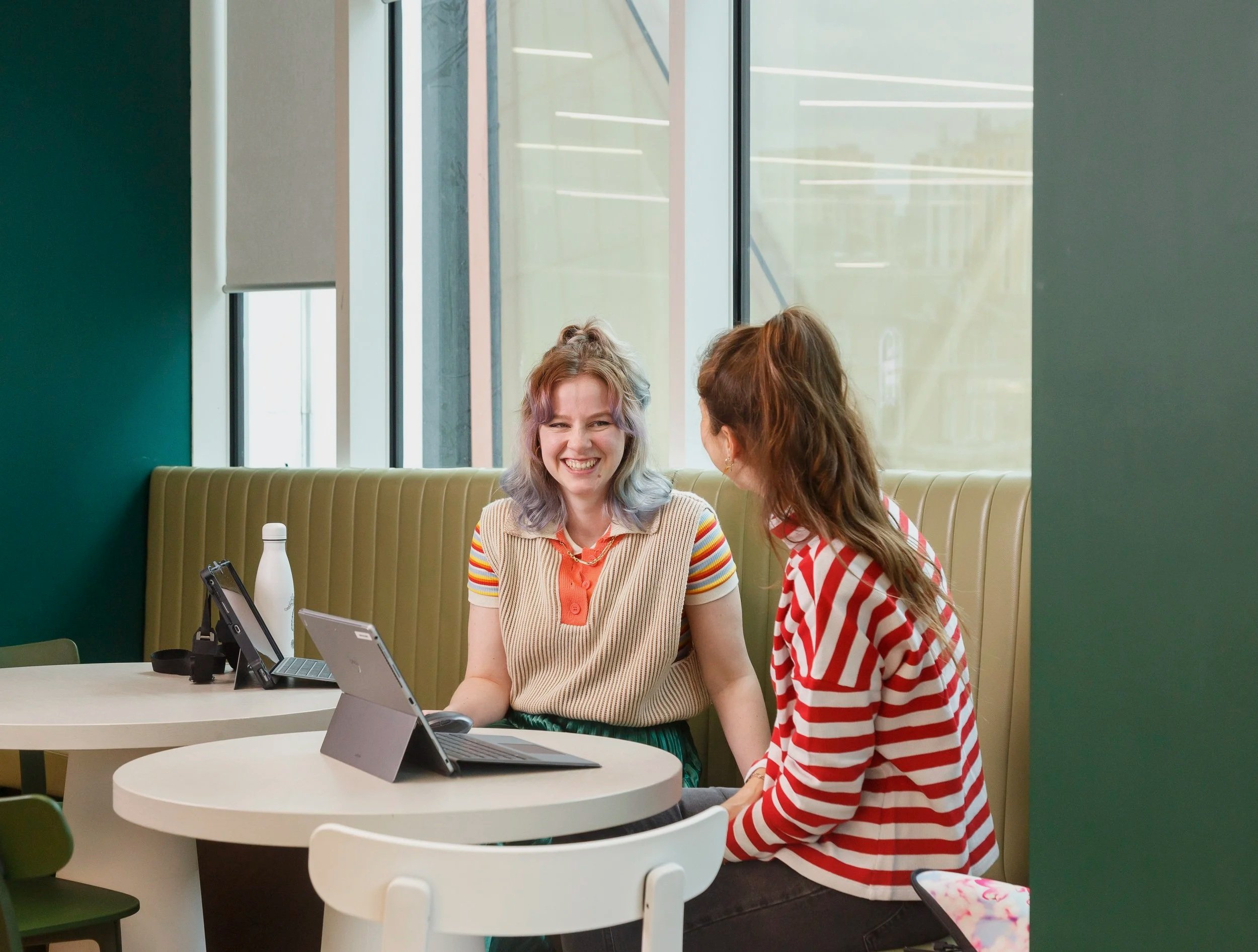 Employees collaborating with laptops in a breakout workspace at TJX Companies head office in Watford, commercial corporate photography capturing modern office culture.