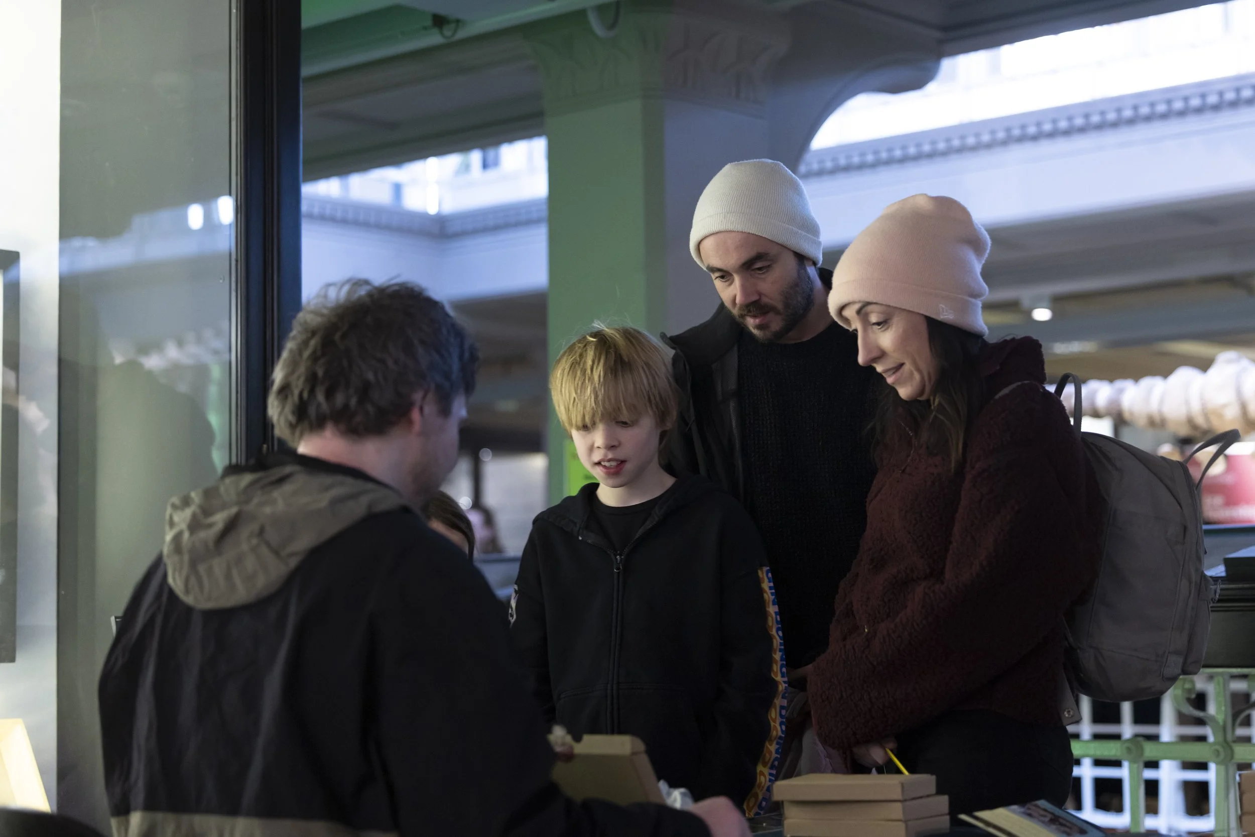 Family exploring objects and materials on table during interactive workshop at EarthSonic Live, Manchester Museum