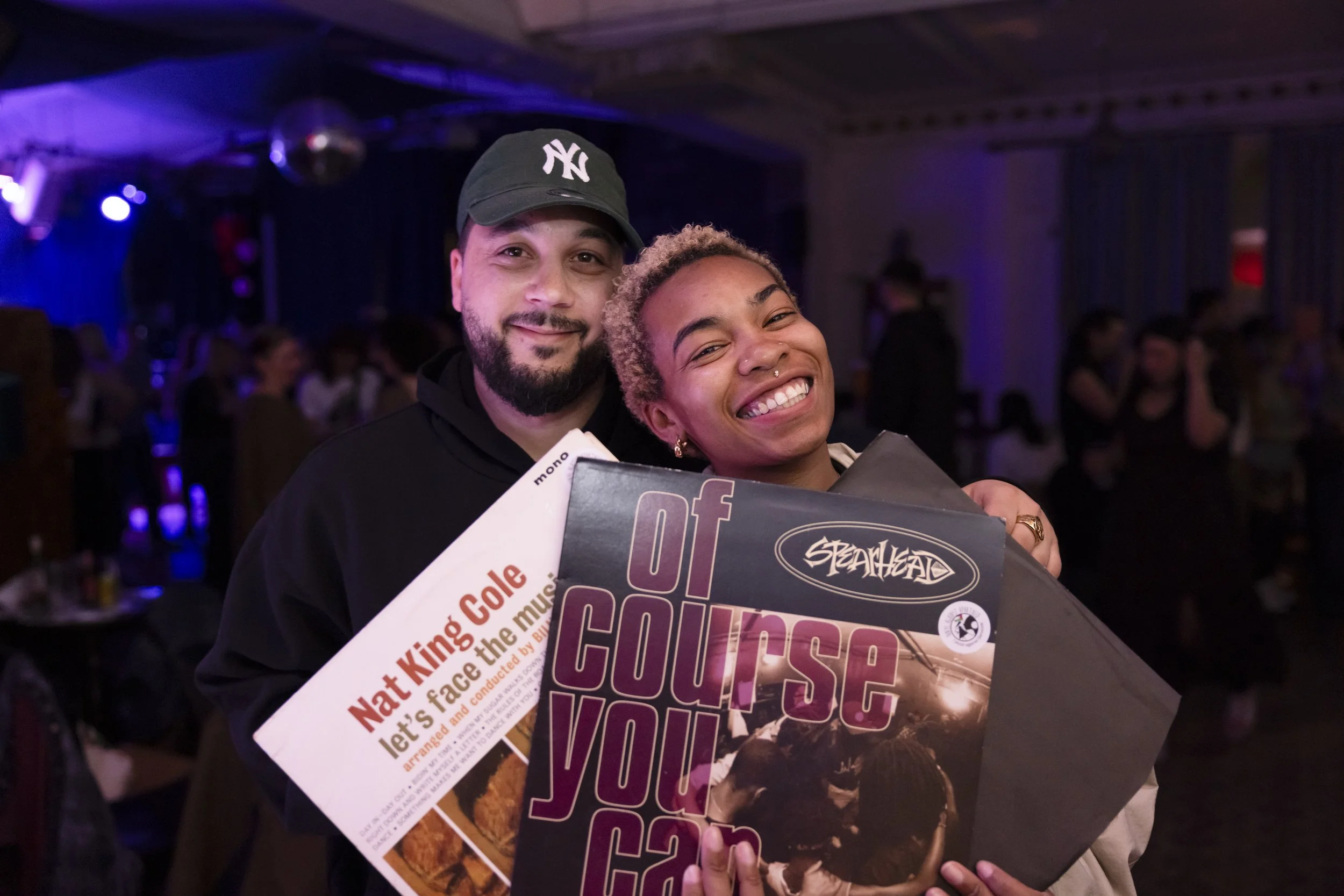 Couple holding vinyl records purchased at grassroots music event in Manchester