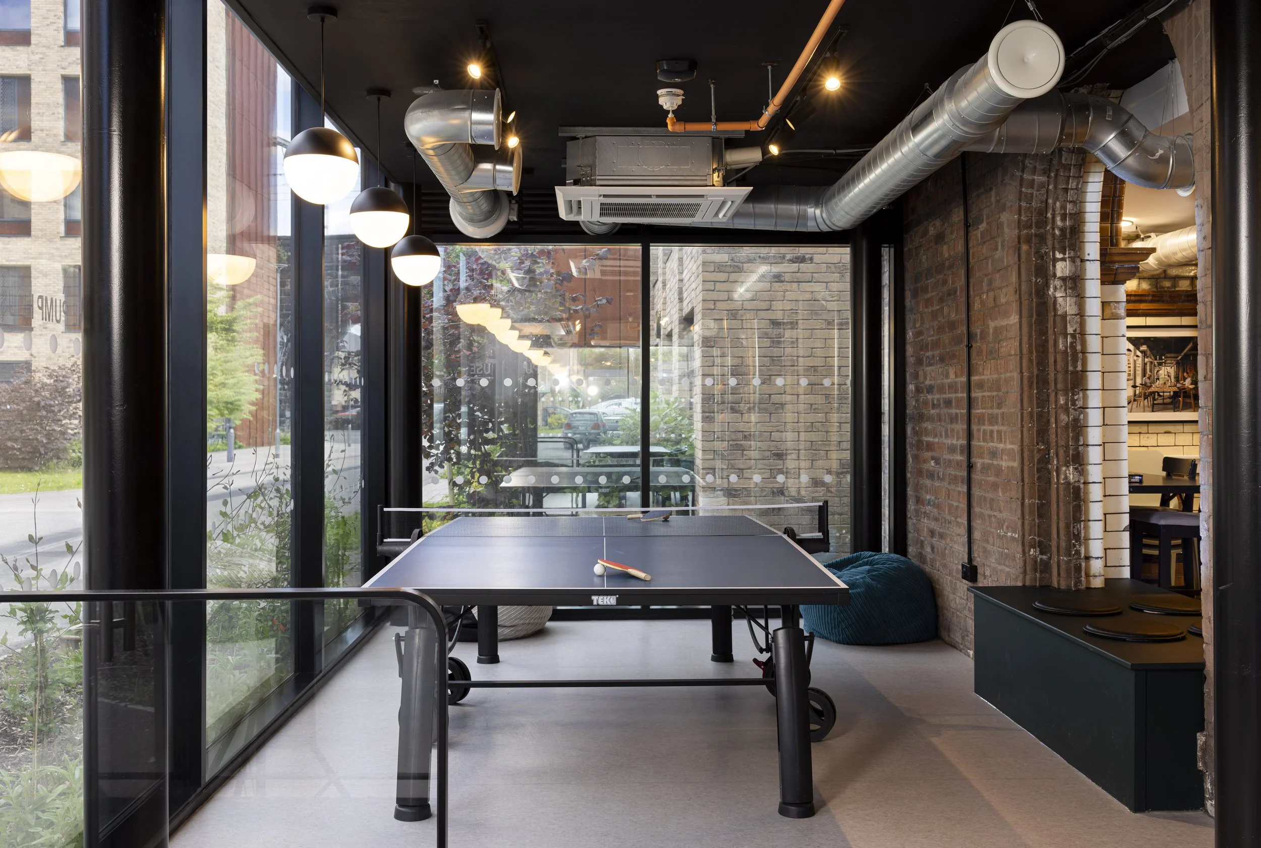 Foyer entrance of The Pump House by Just H Architects shown from above with table tennis table in converted industrial space