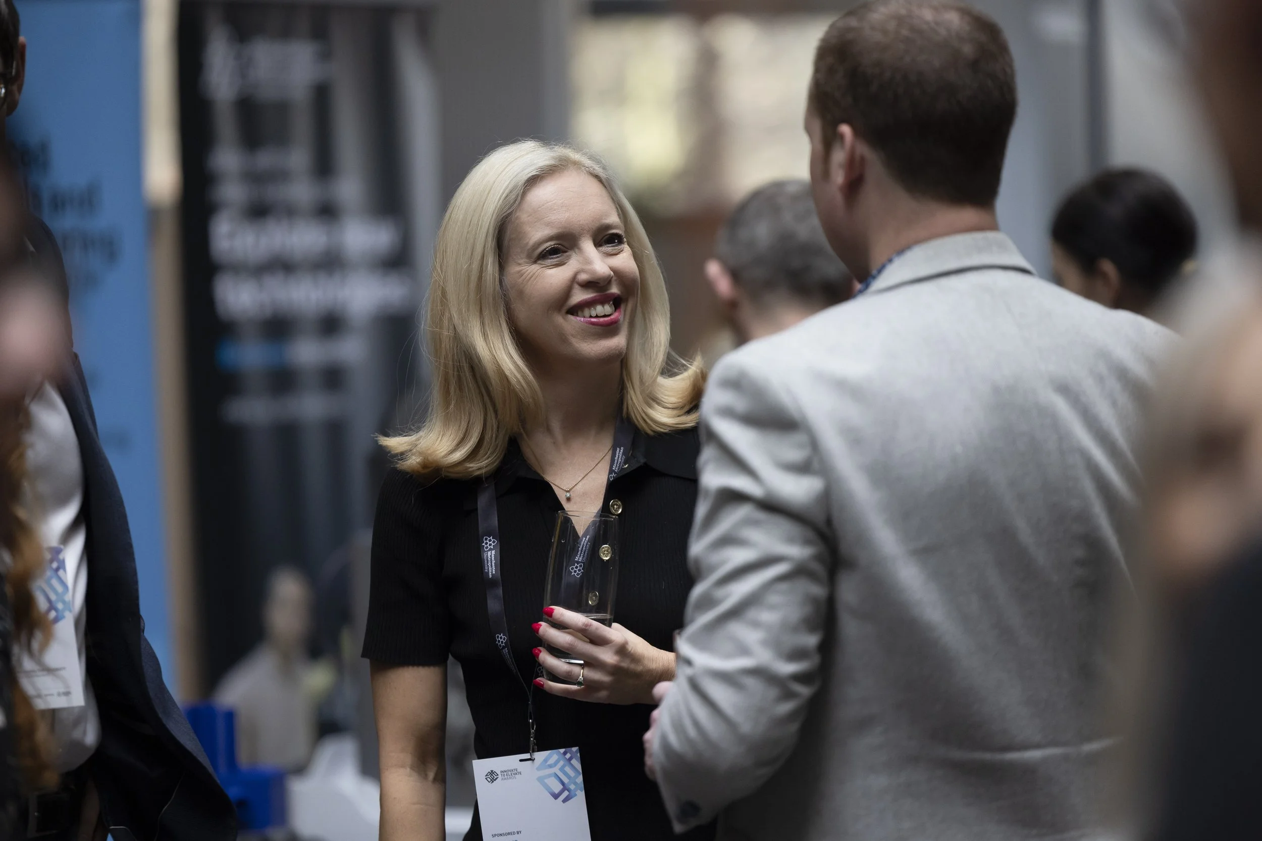 A woman smiling during networking during a conference in Manchester