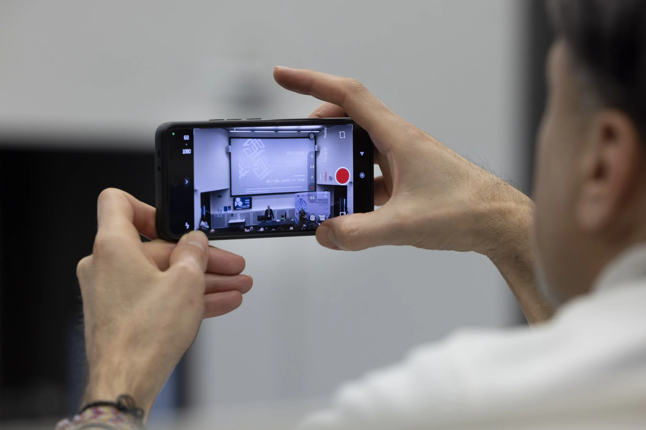A delegate films a presentation curing a conference in Manchester