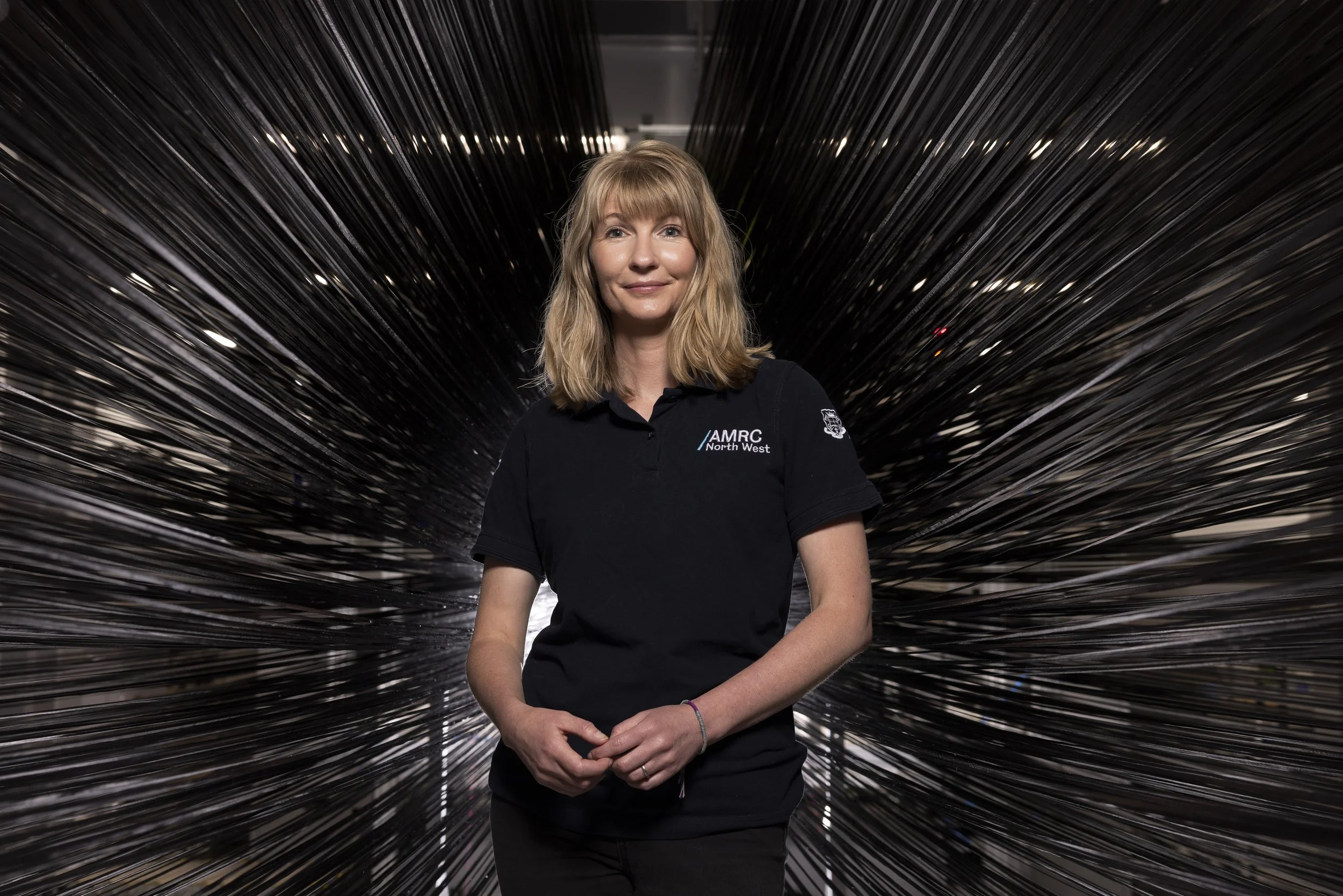 Kristina Parry inside an industrial research machine surrounded by splayed carbon fibre materials, editorial photography for Connected Places Catapult innovation feature
