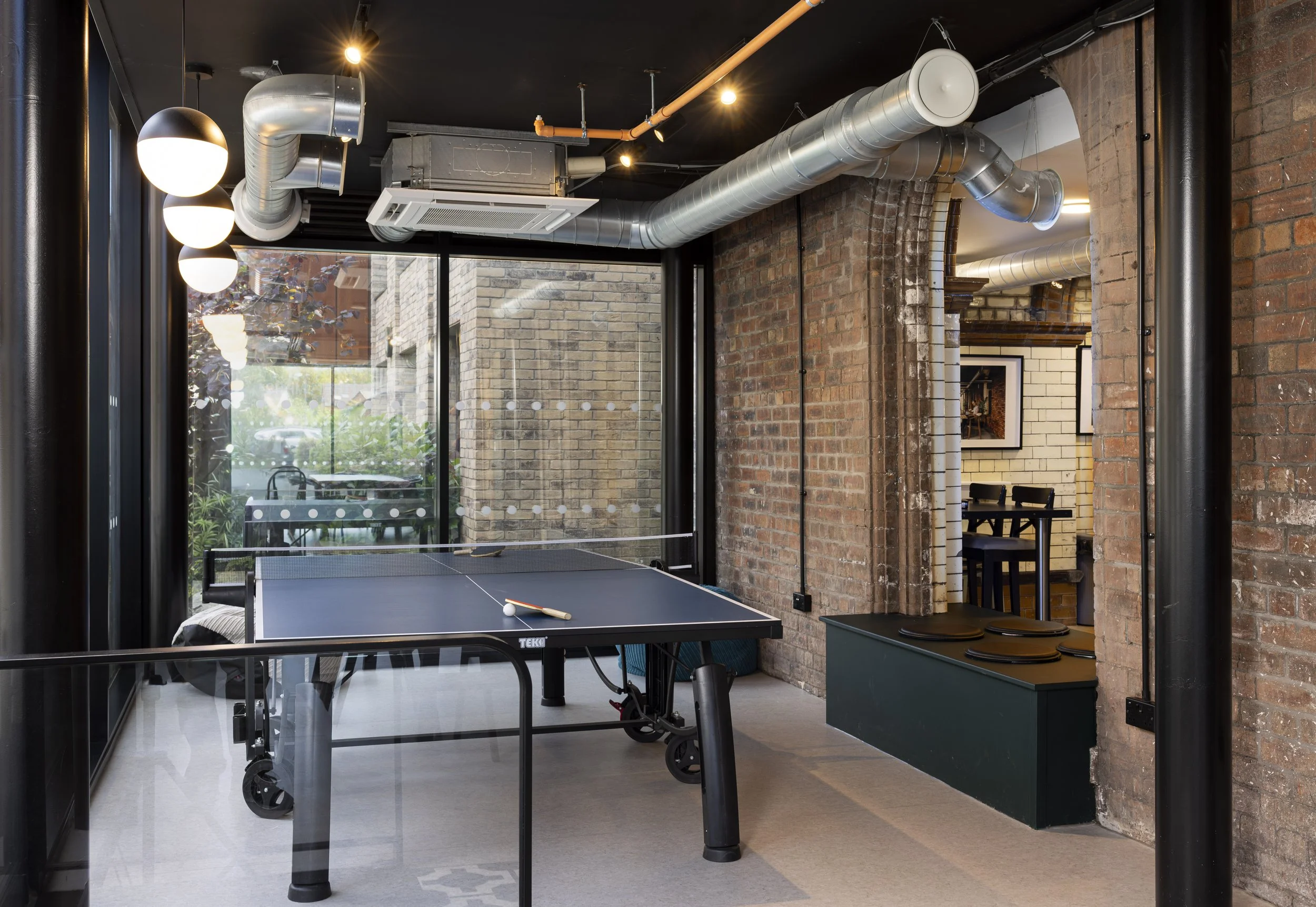 Interior foyer of The Pump House by Just H Architects featuring table tennis table in converted industrial entrance space