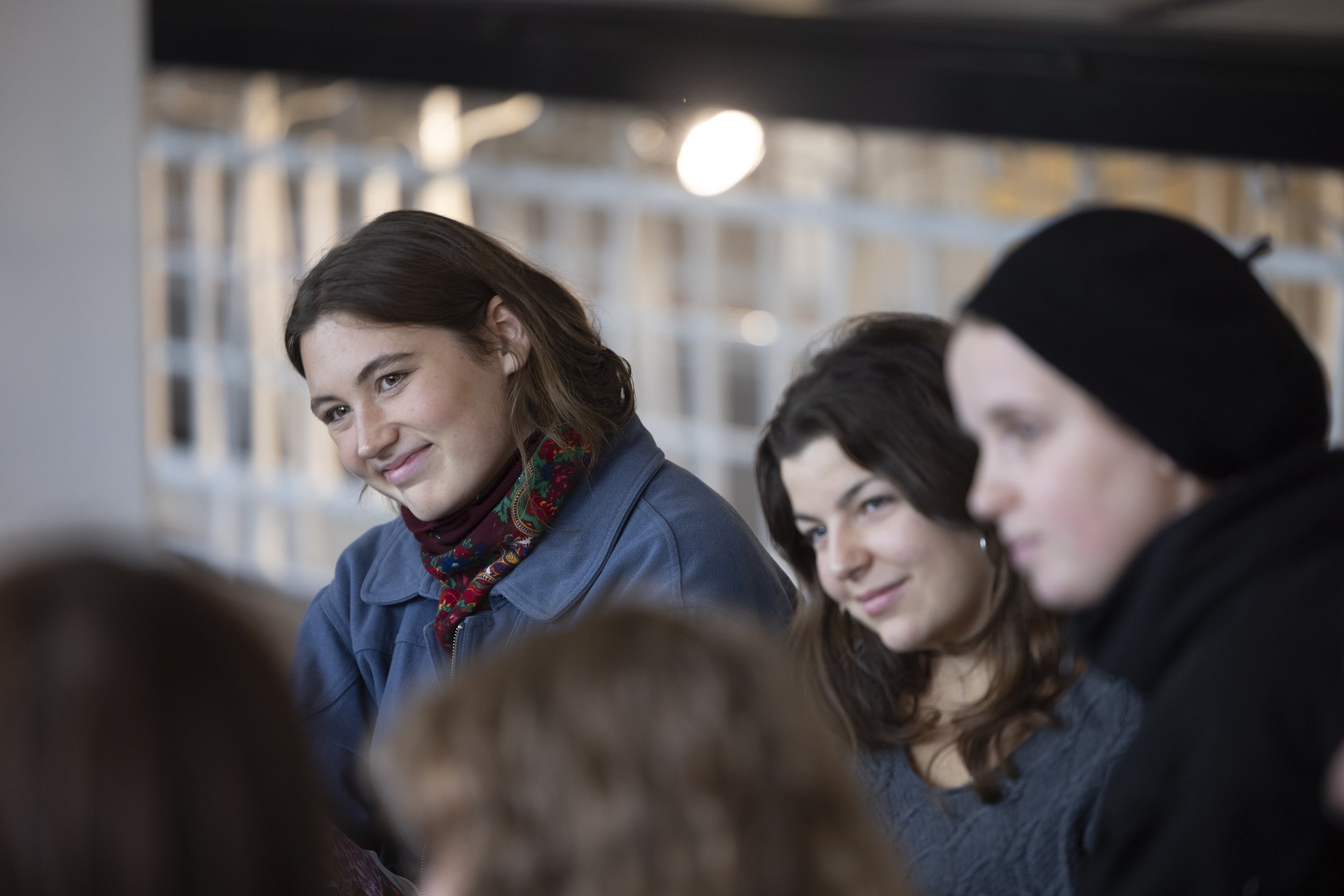 Young speaker smiling during panel discussion on music and climate at EarthSonic Live, Manchester Museum