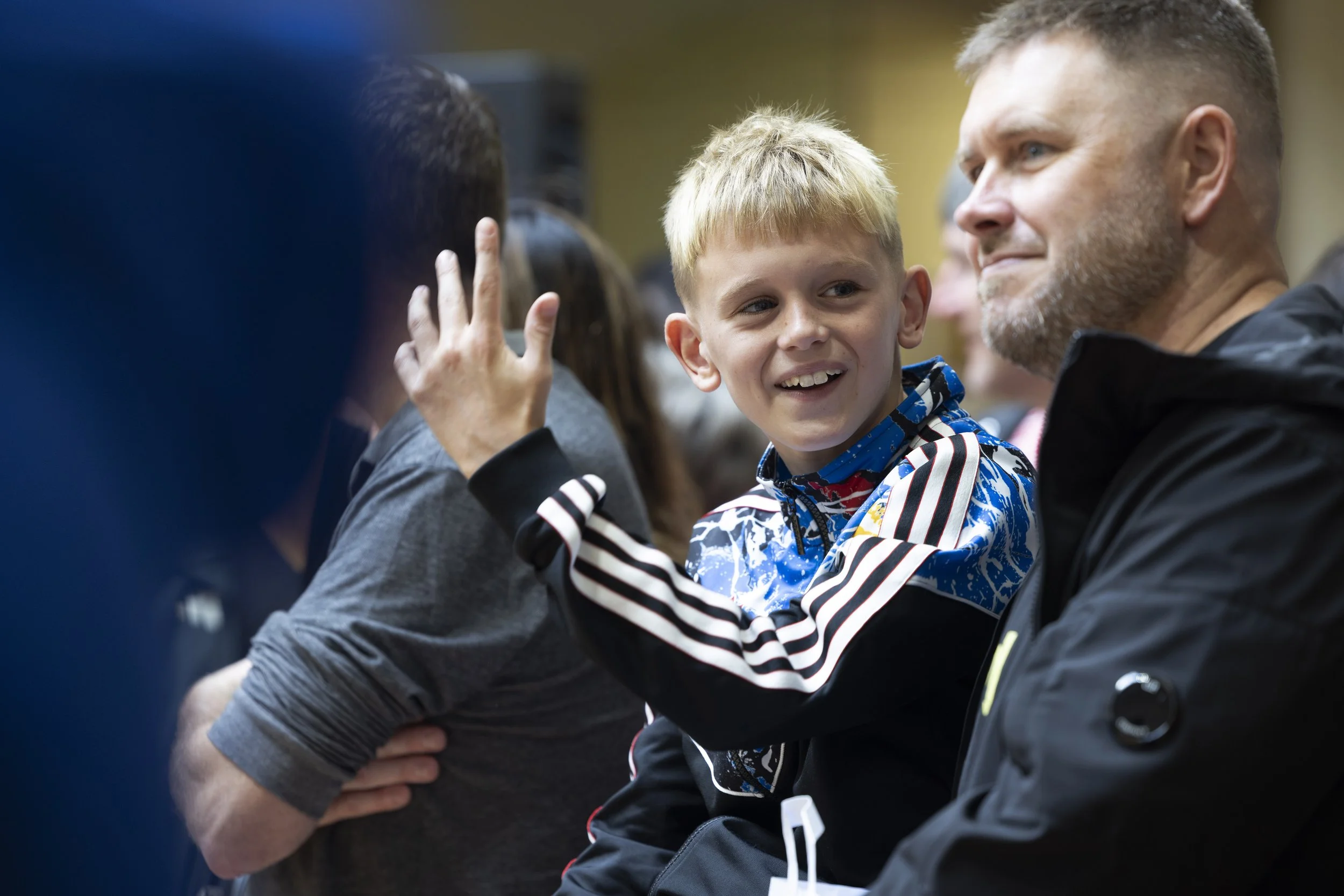 A young Manchester United fan laughs and talks with his father during the third kit launch at Salford Lads & Girls Club.