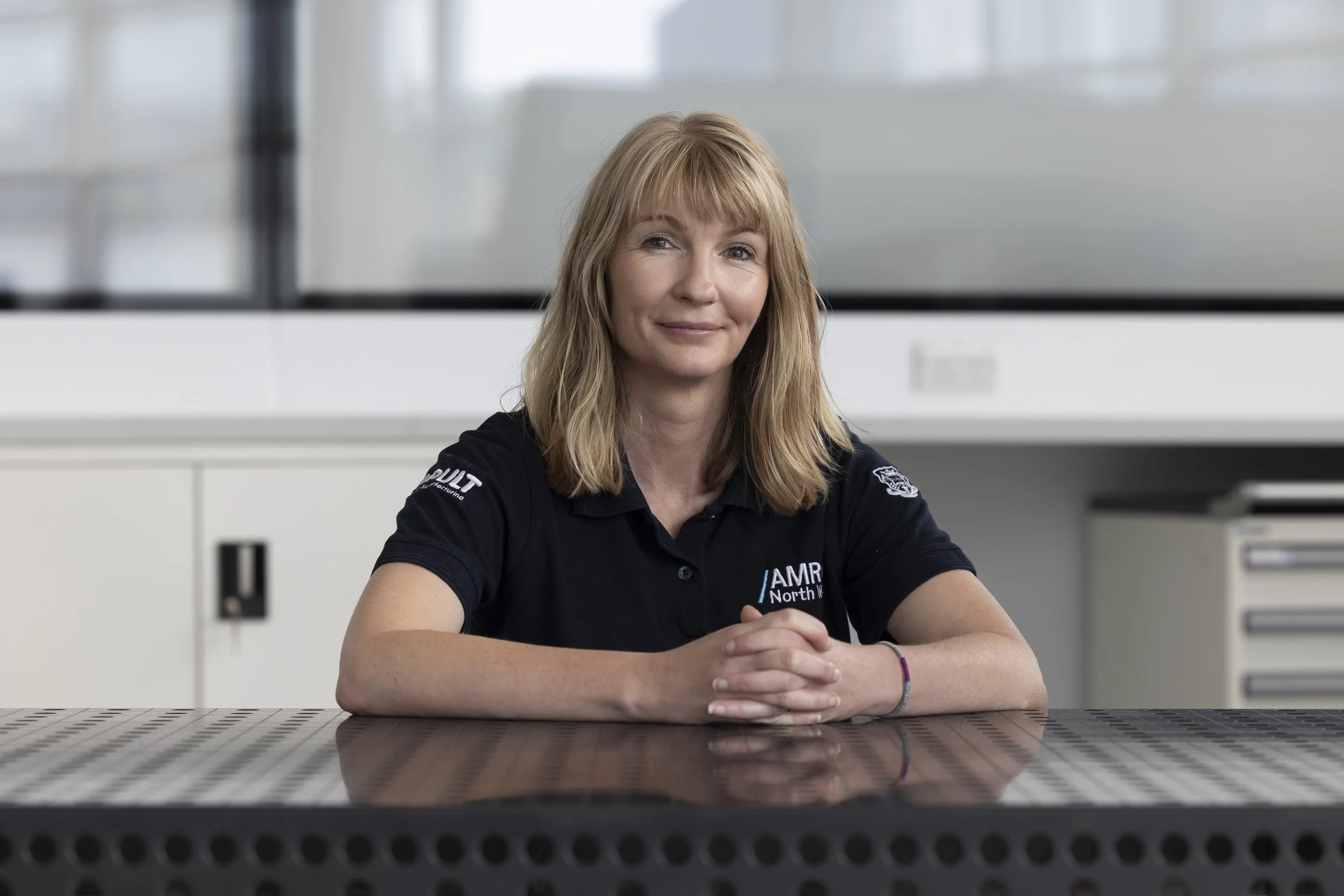Kristina Parry seated at a metal technical workbench, documentary-style portrait photography for Connected Places Catapult research collaboration feature