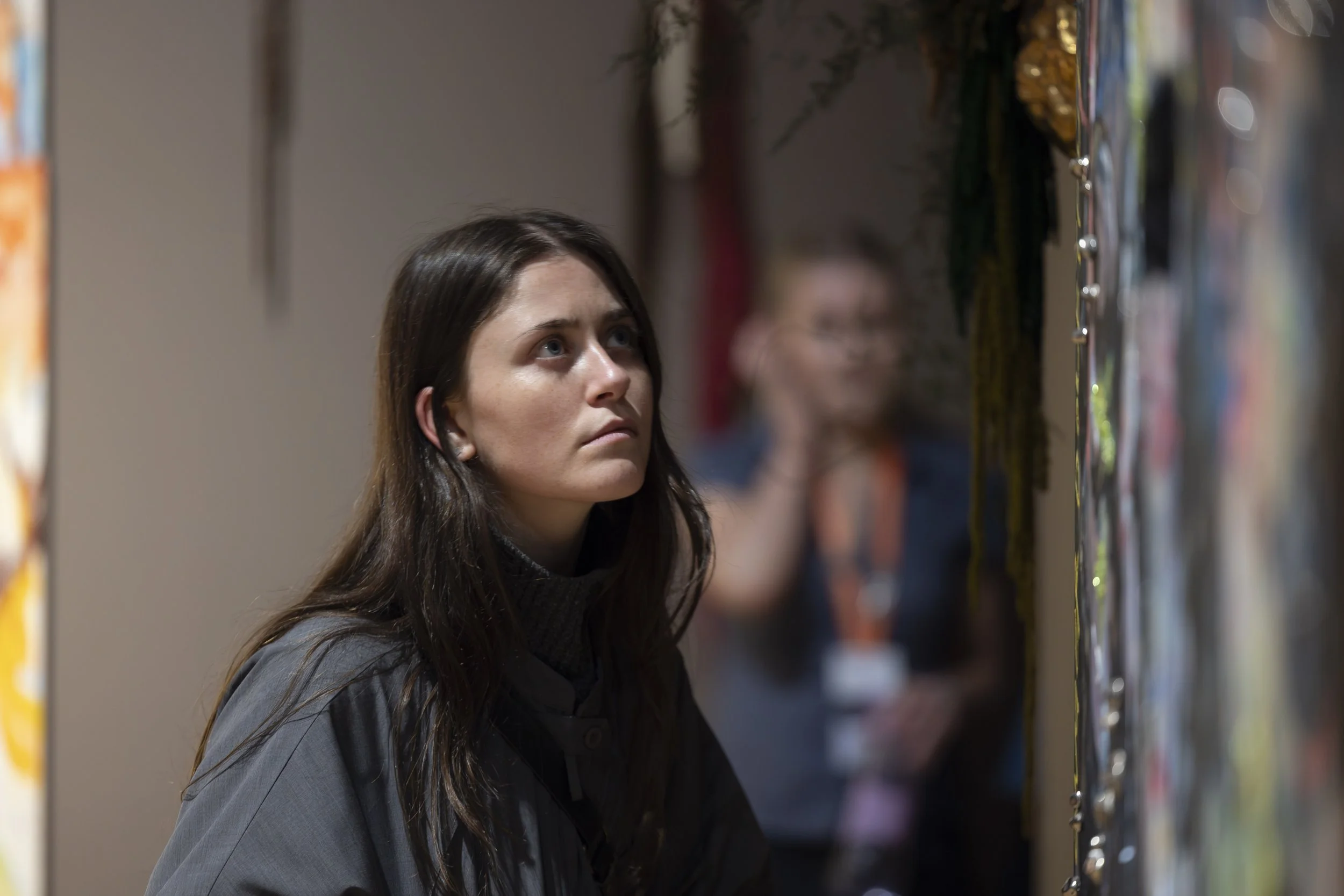 Young woman viewing contemporary painting closely in gallery space at Whitworth Art Gallery.