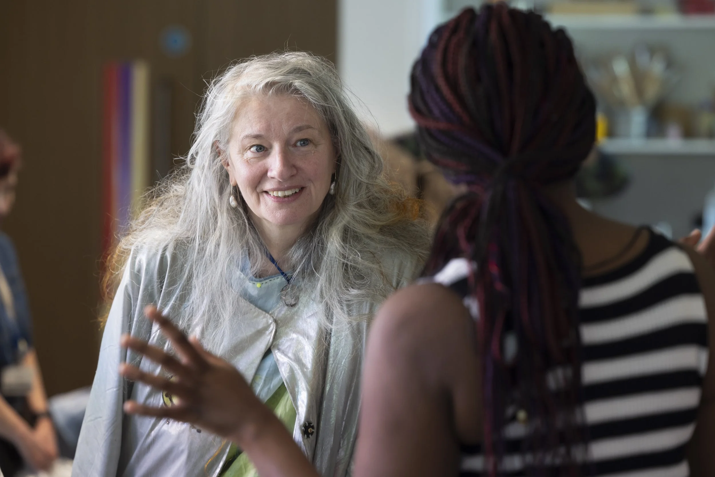 Delaine Le Bas speaking with a workshop participant during an upcycling and textile art session at The Whitworth, Manchester, collaborative contemporary art and material practice