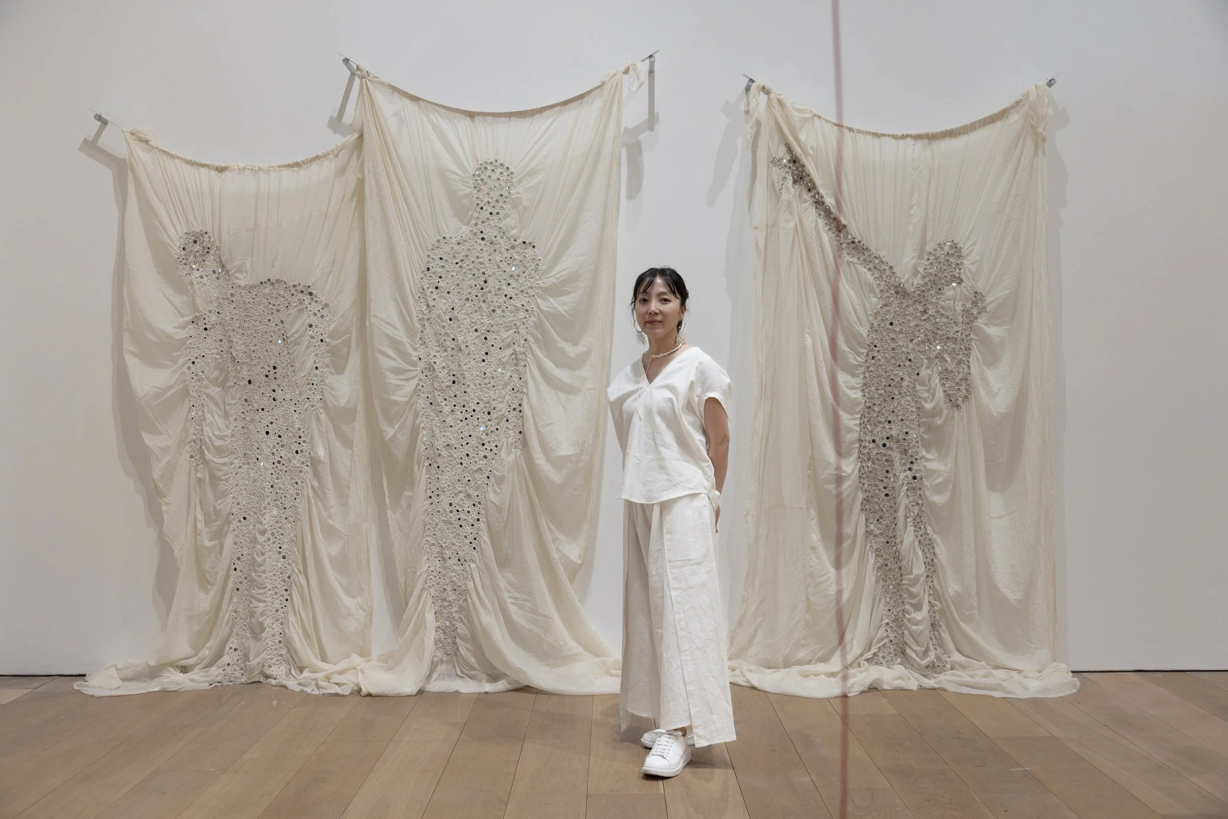 Artist Young In Hong with her mirror-embedded textile works at the Whitworth Art Gallery, Manchester