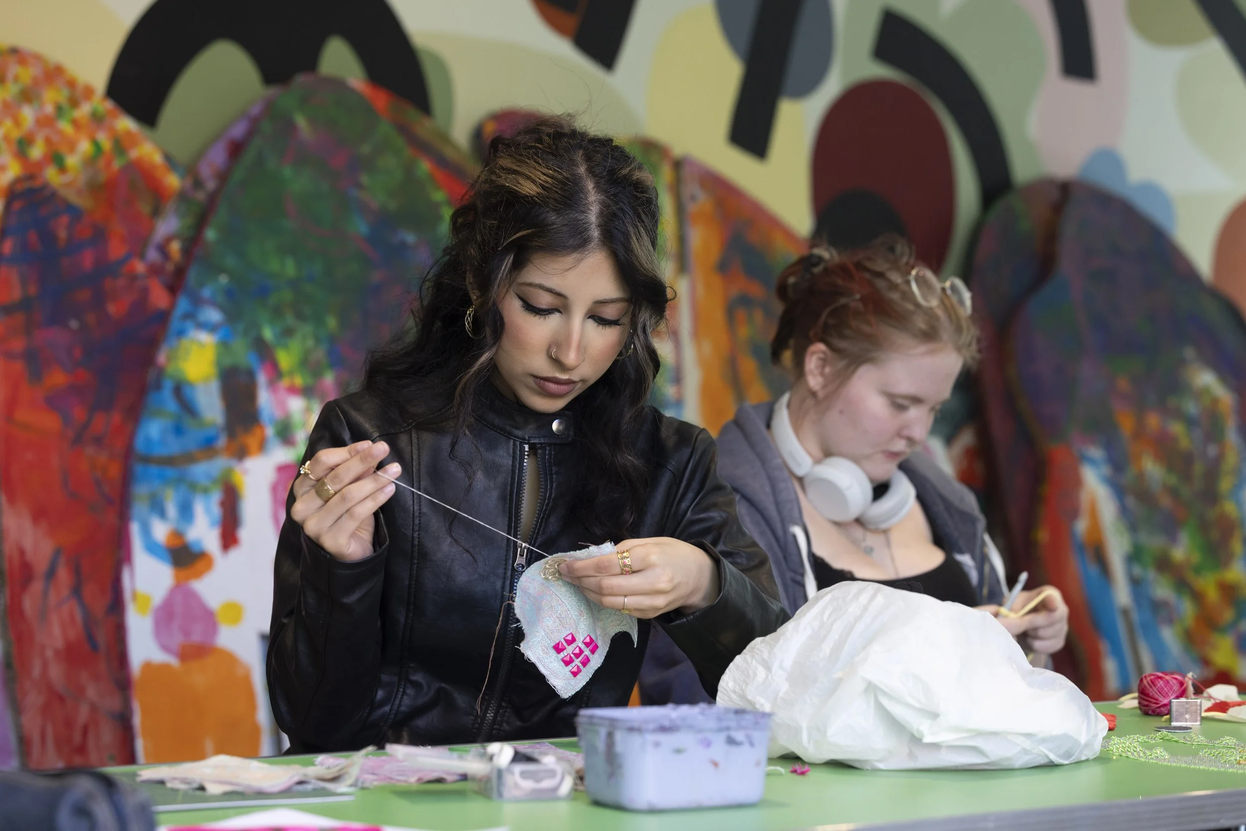 Two young women sewing textiles during a collaborative upcycling workshop at The Whitworth, Manchester, documentary photography of fashion and material experimentation