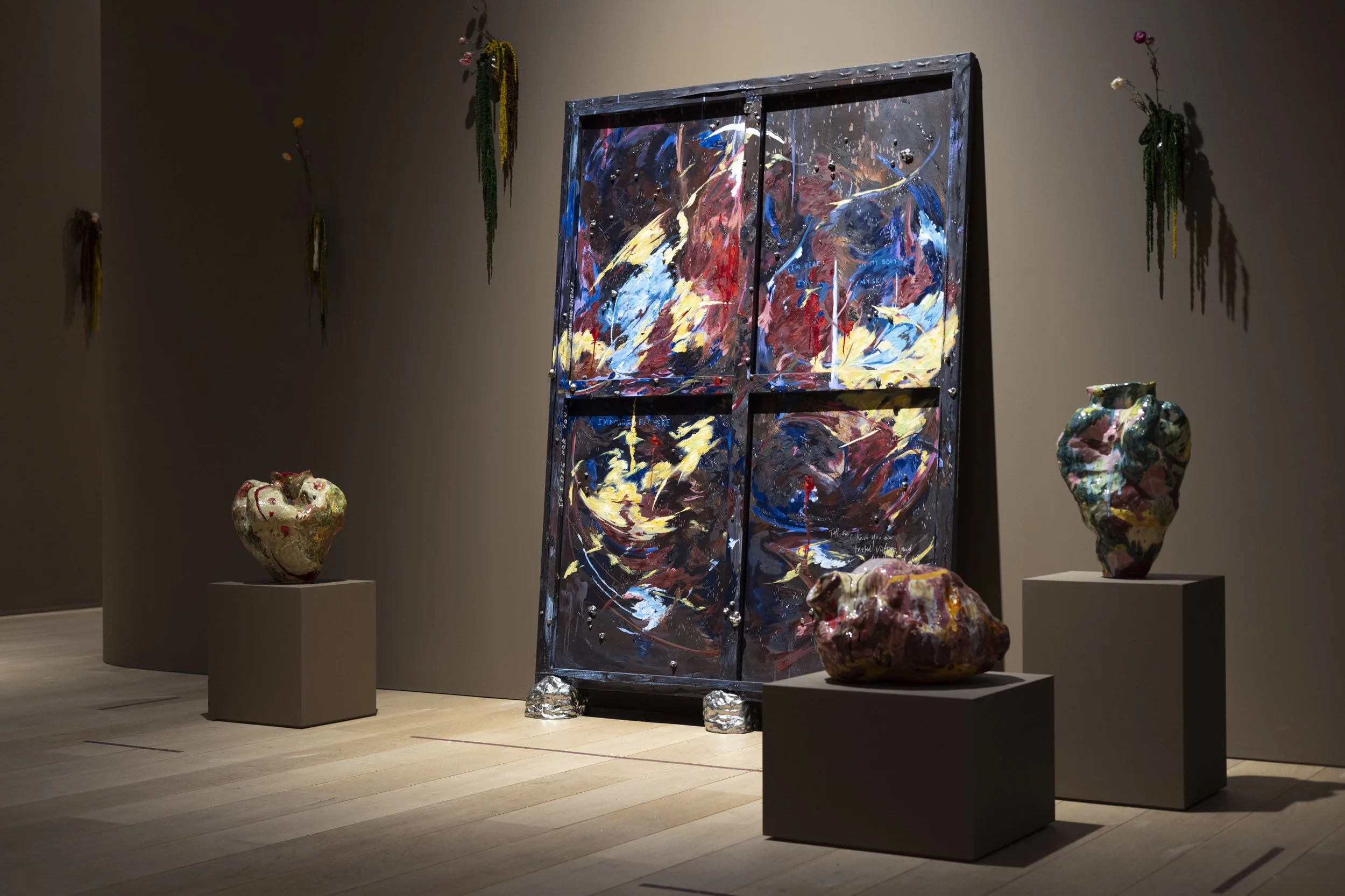 Contemporary painting leaning against gallery wall with three ceramic sculptures installed in front.