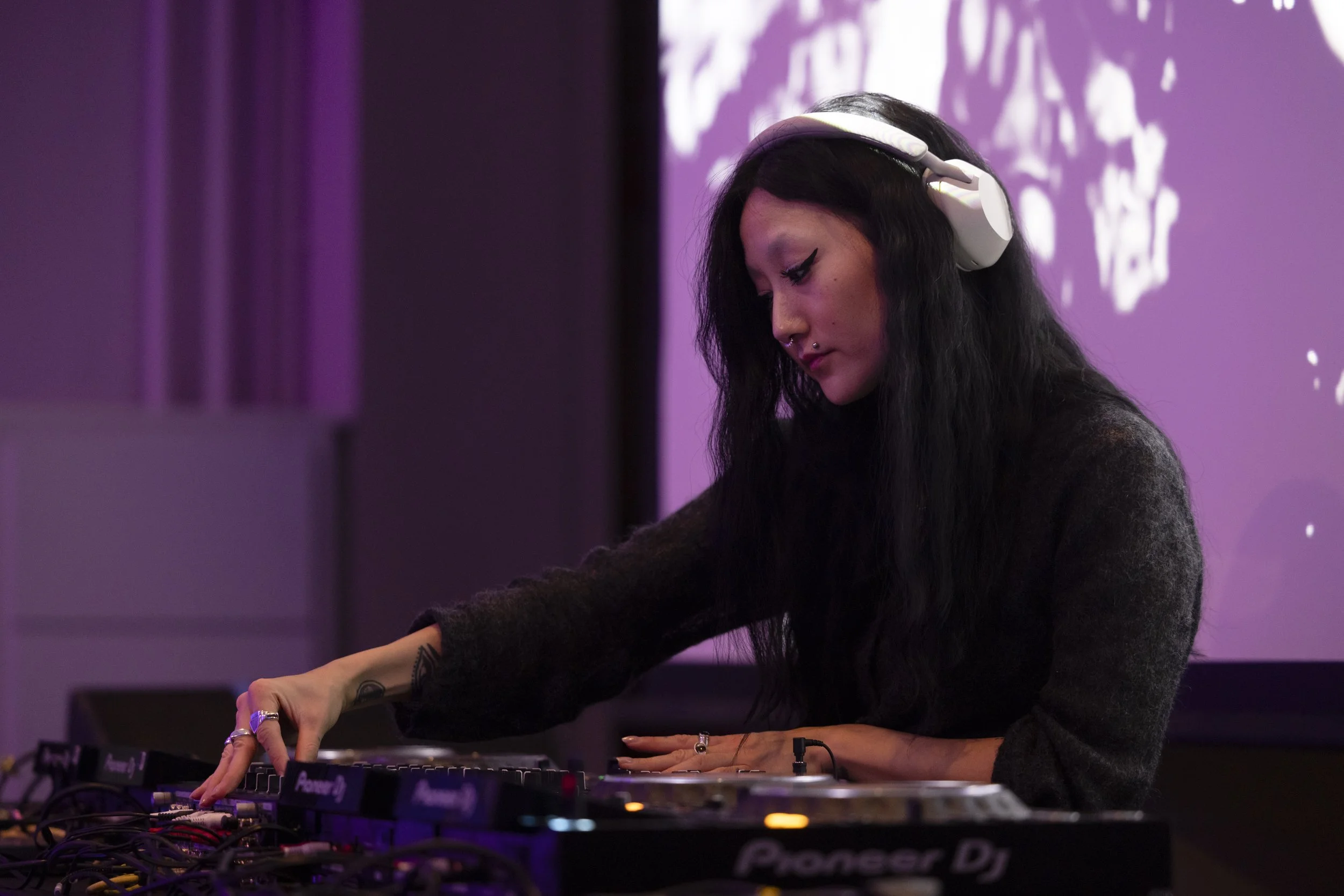 DJ performing live electronic music set on stage at EarthSonic Live, Manchester Museum