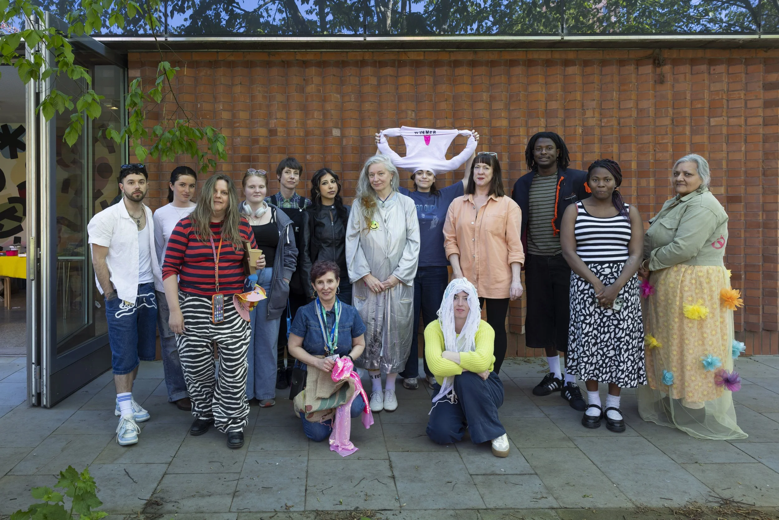 Group of workshop participants and artists gathered during an upcycling workshop at The Whitworth, Manchester, documentary photography of collaborative textile and contemporary art practice
