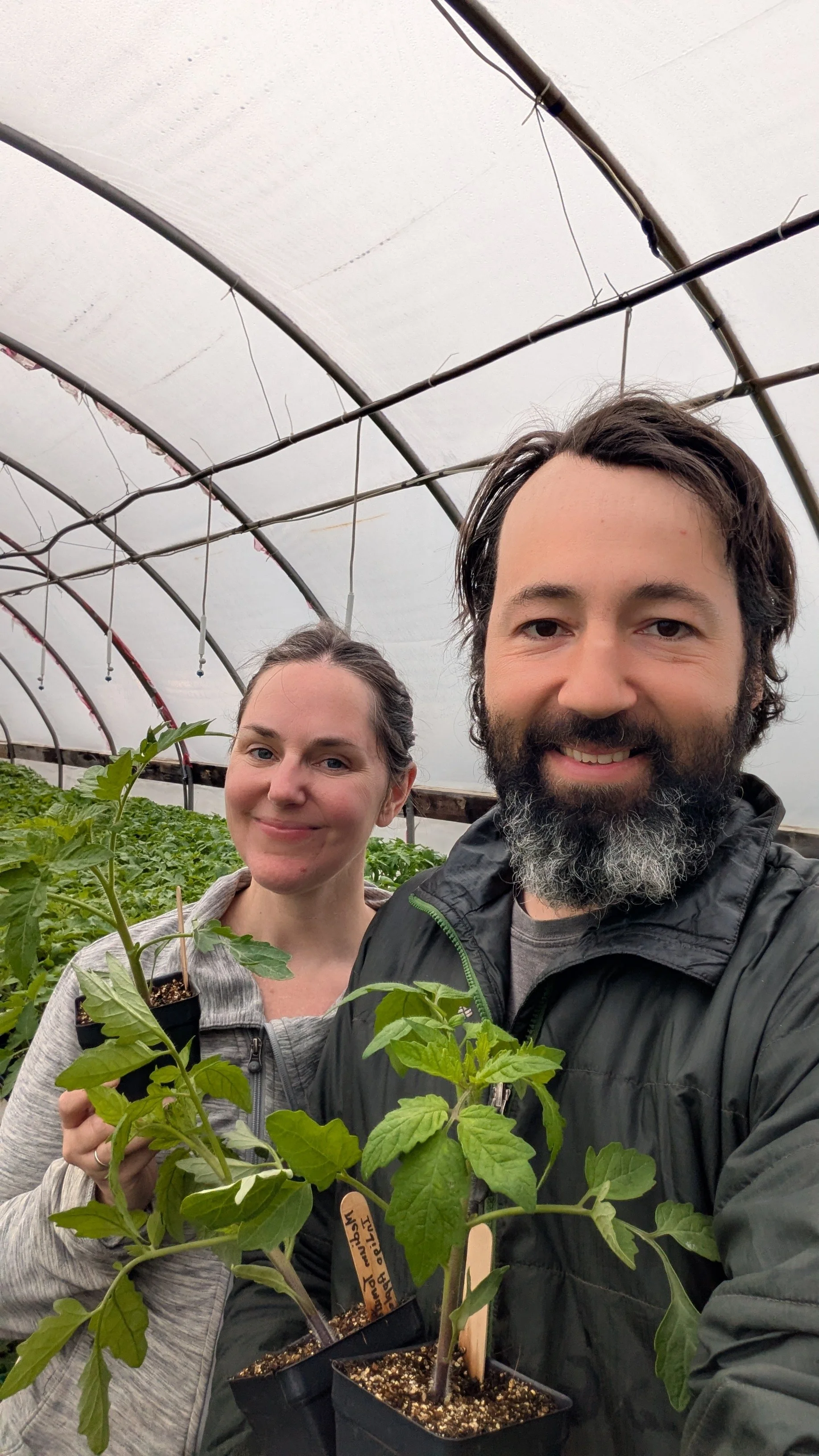 Alex and Kim of Mulberry Moon Farm holding their organic seedlings, ready for the annual seedling sale.