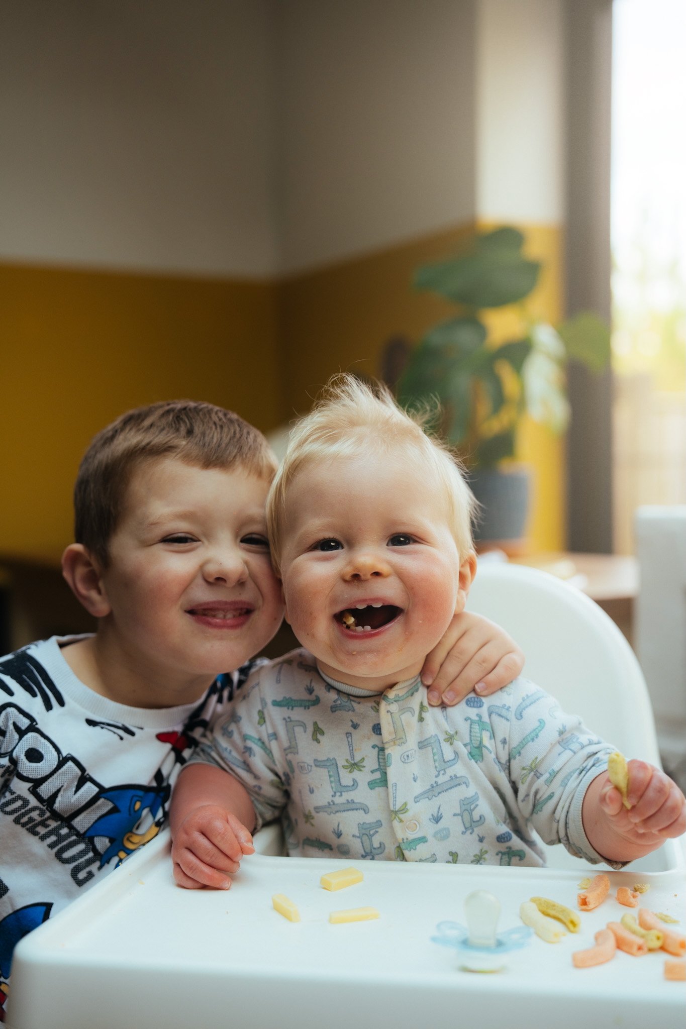 Two toddlers laughing together — joyful family and child portrait photography