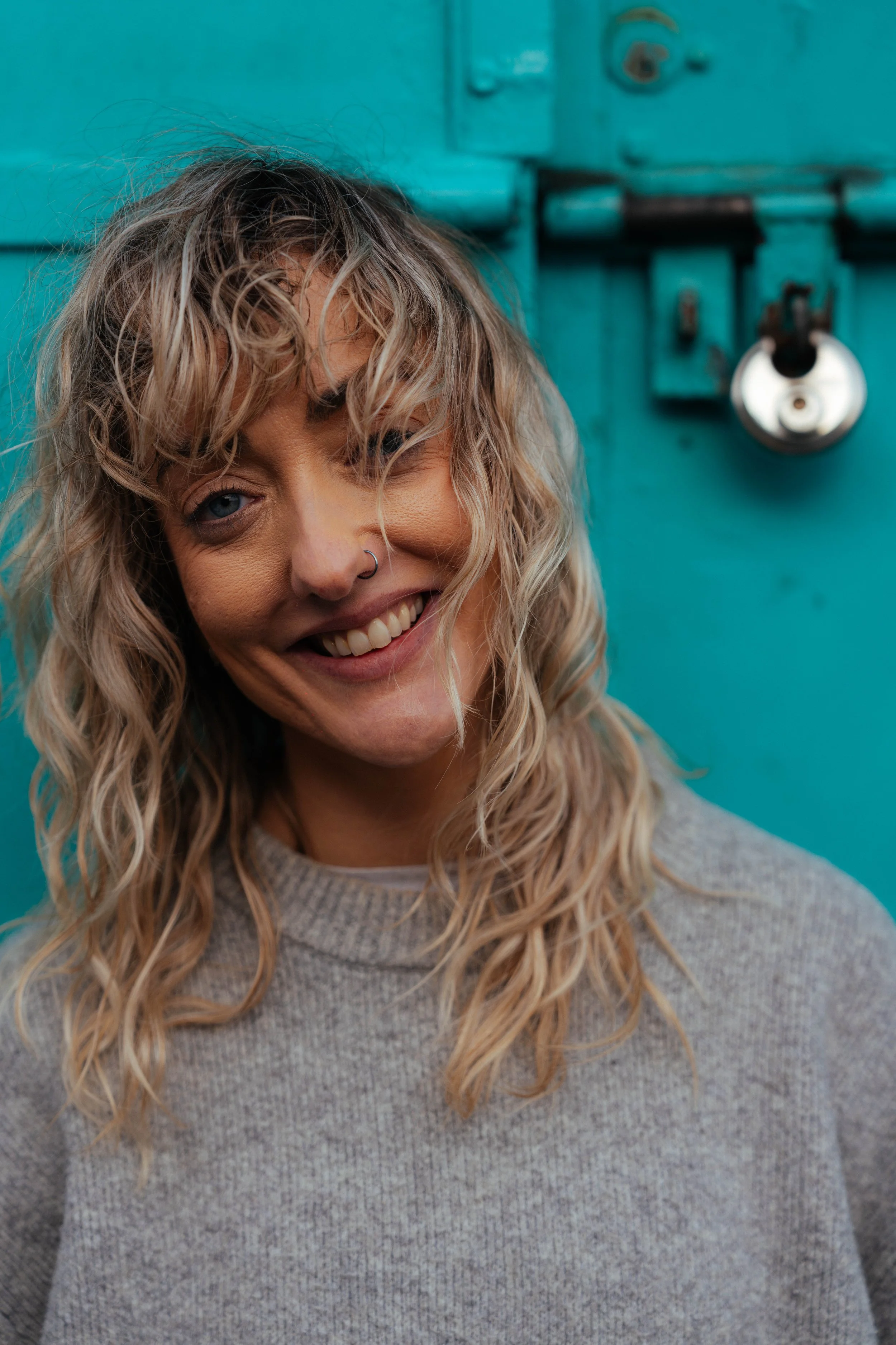 Close-up portrait of woman with curly hair smiling — natural light location photography