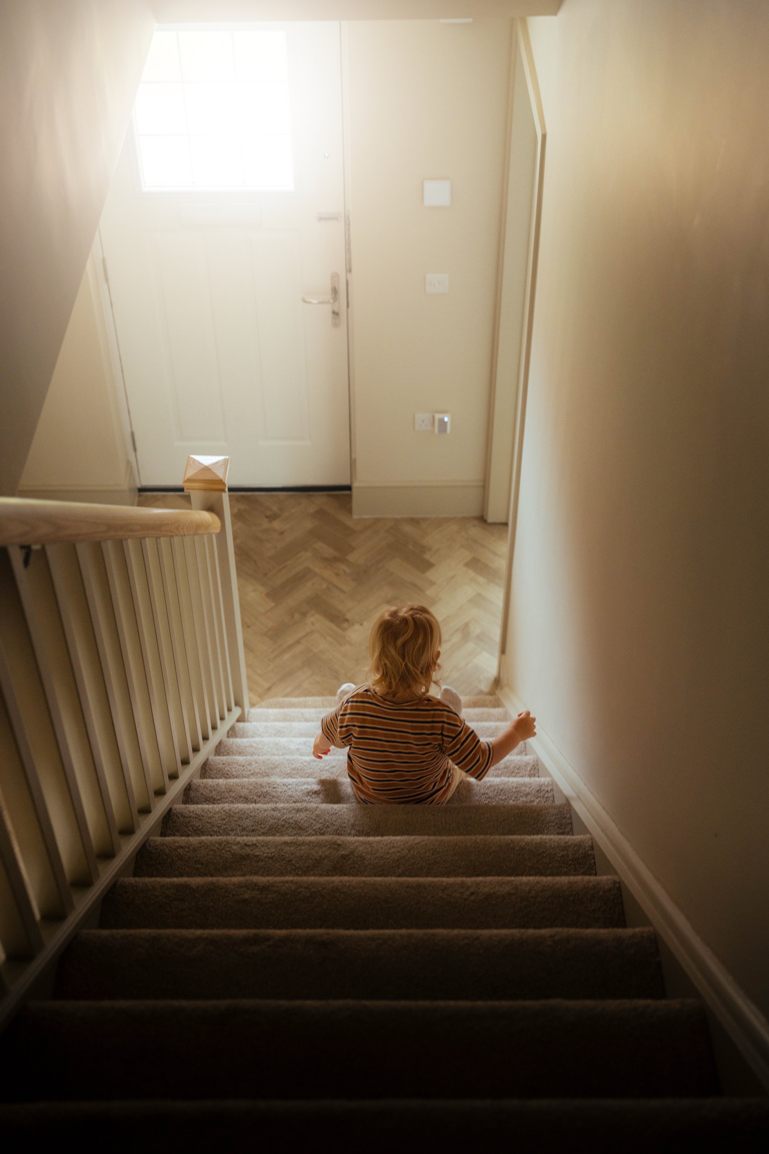 Young child at the bottom of a staircase — family lifestyle photography