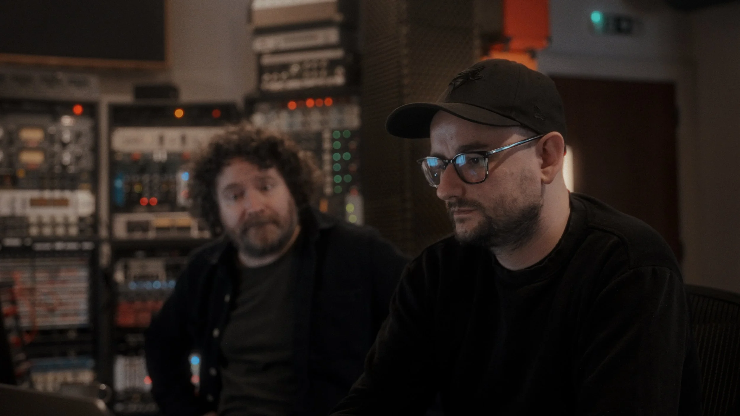 Two people at a recording console — music production session photography