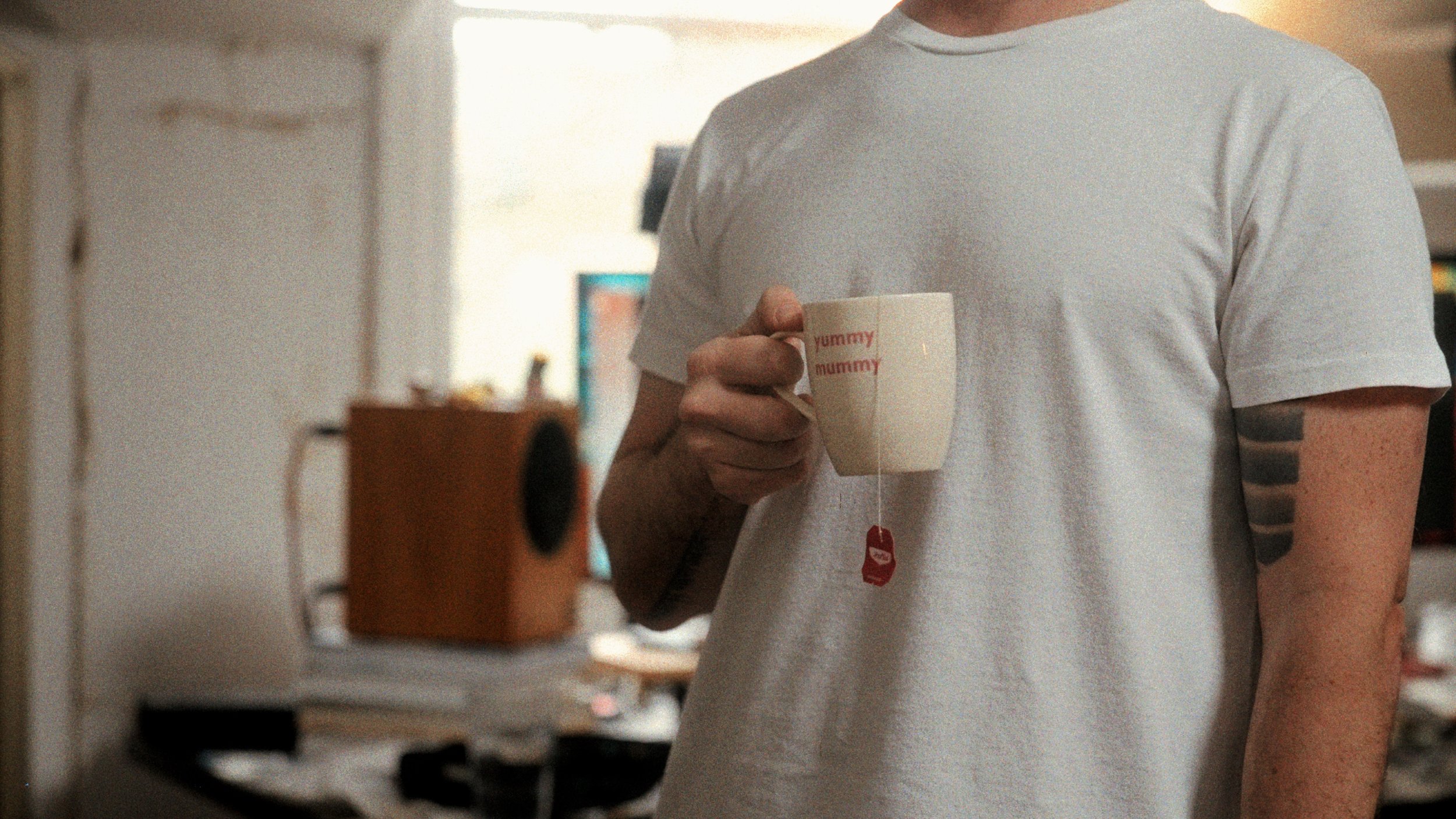 Person holding a coffee mug in a creative workspace — lifestyle photography