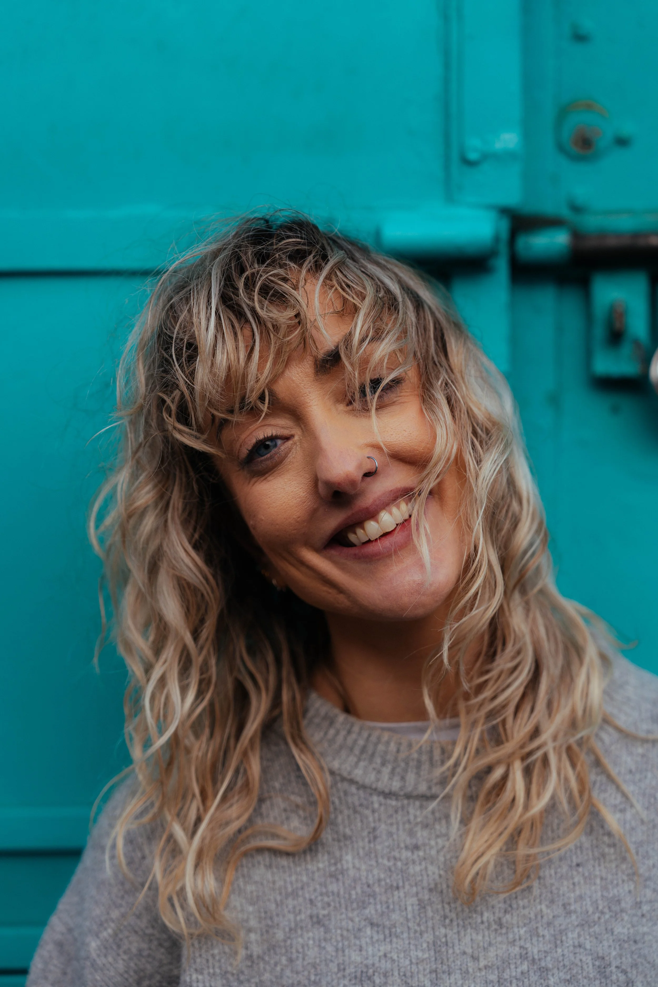 Portrait session — woman with curly hair, teal wall background, Liverpool photographer