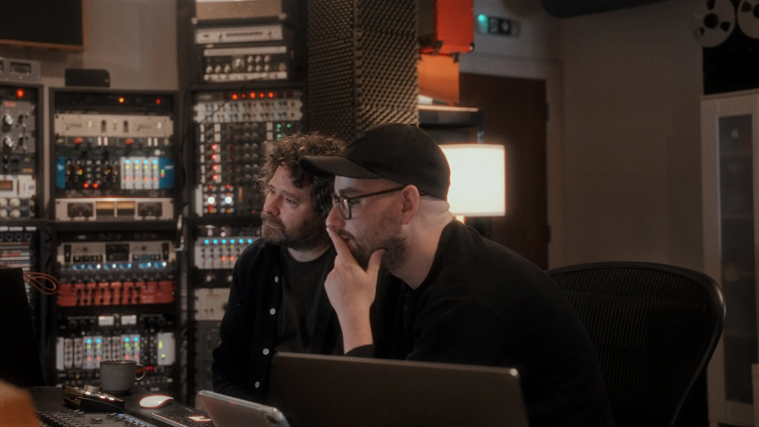 Music producers at a mixing desk in a recording studio — behind the scenes photography