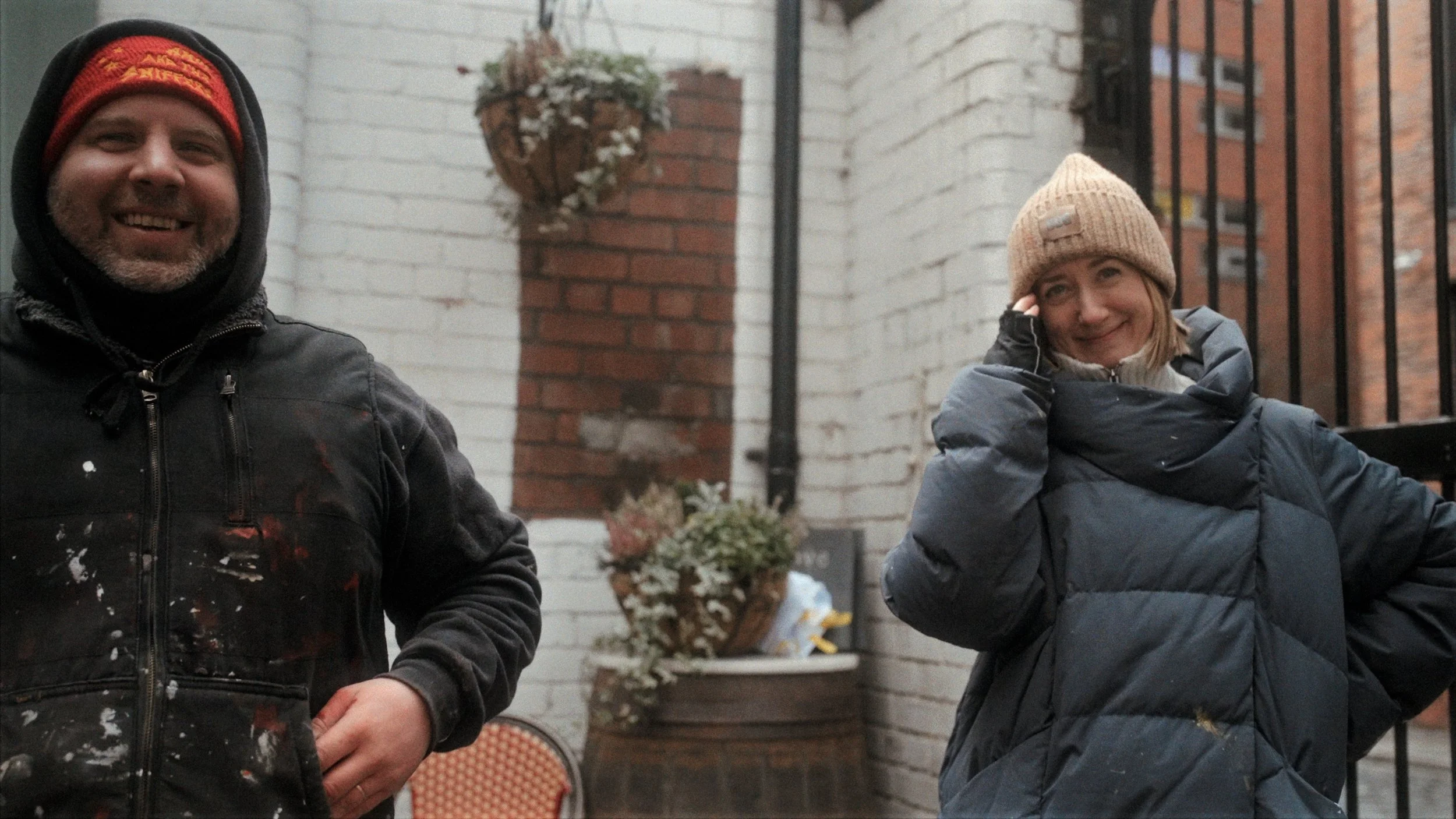 Person in beanie hat outdoors smiling — candid documentary portrait photography