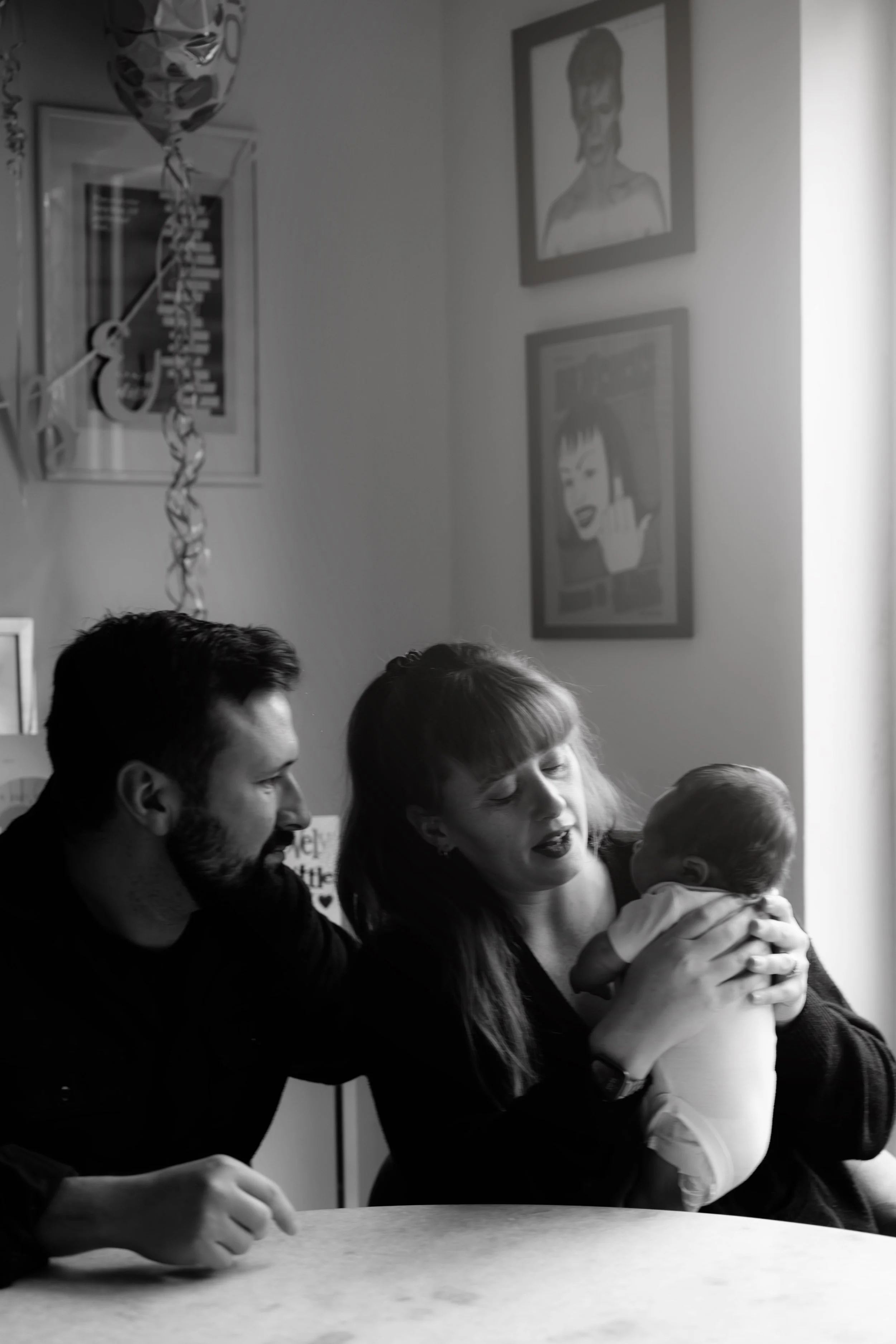 Parents with their newborn baby at home — black and white family lifestyle photography