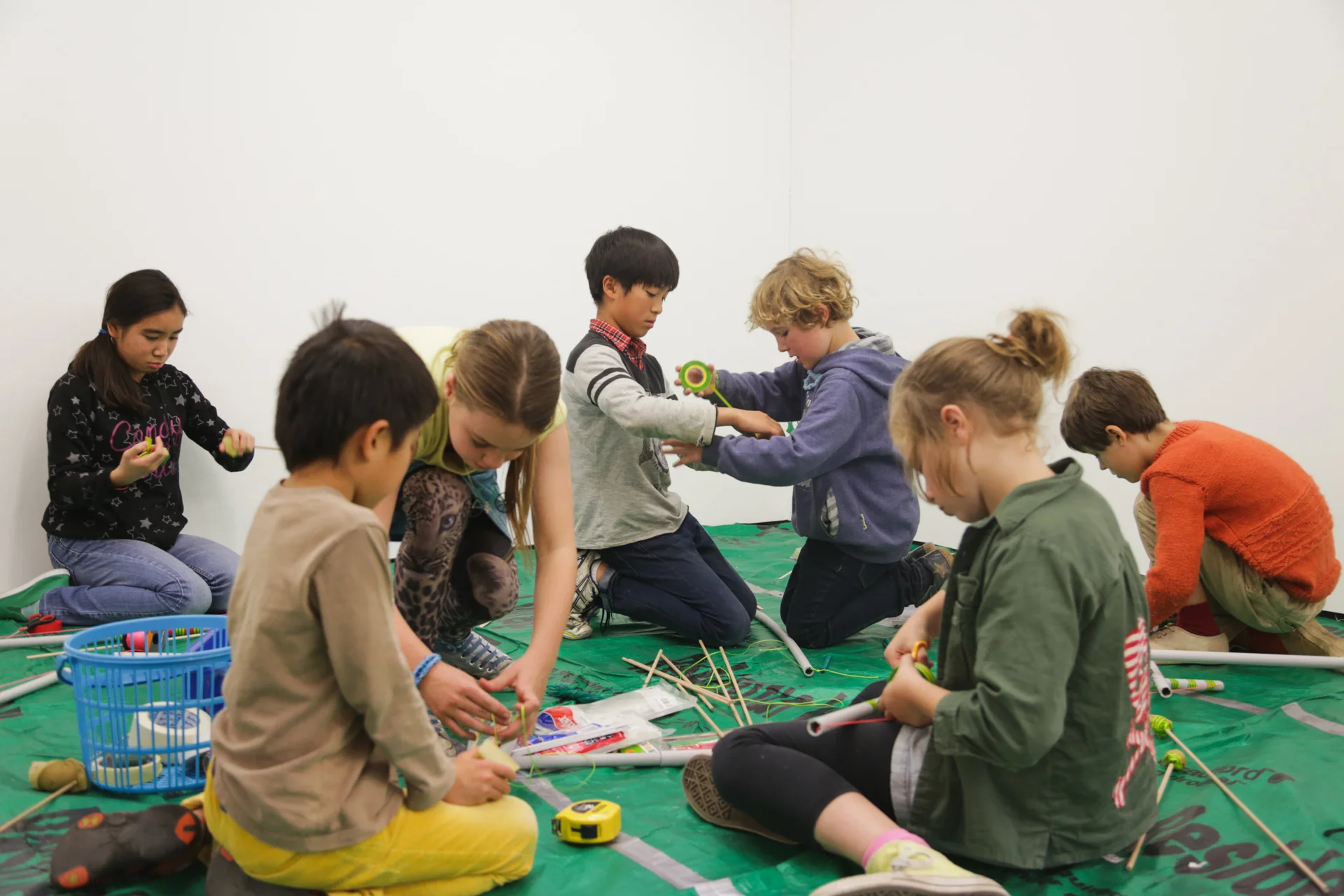 Inez (3rd from the left) and Ringo (4th from the left) are running the Bow and Arrow making (designed by Ringo Watanabe) workshop for children. Photo: Chaco Kato