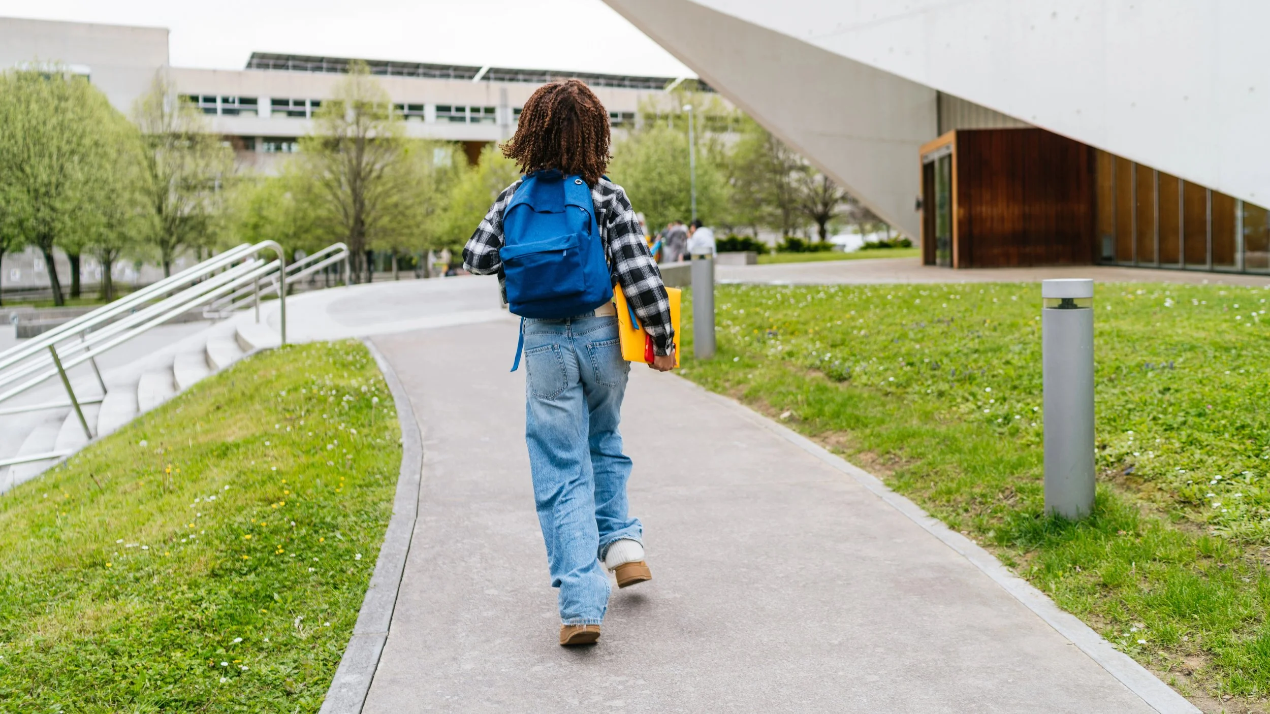 student backpack child wallking away with a book widescreen.jpg