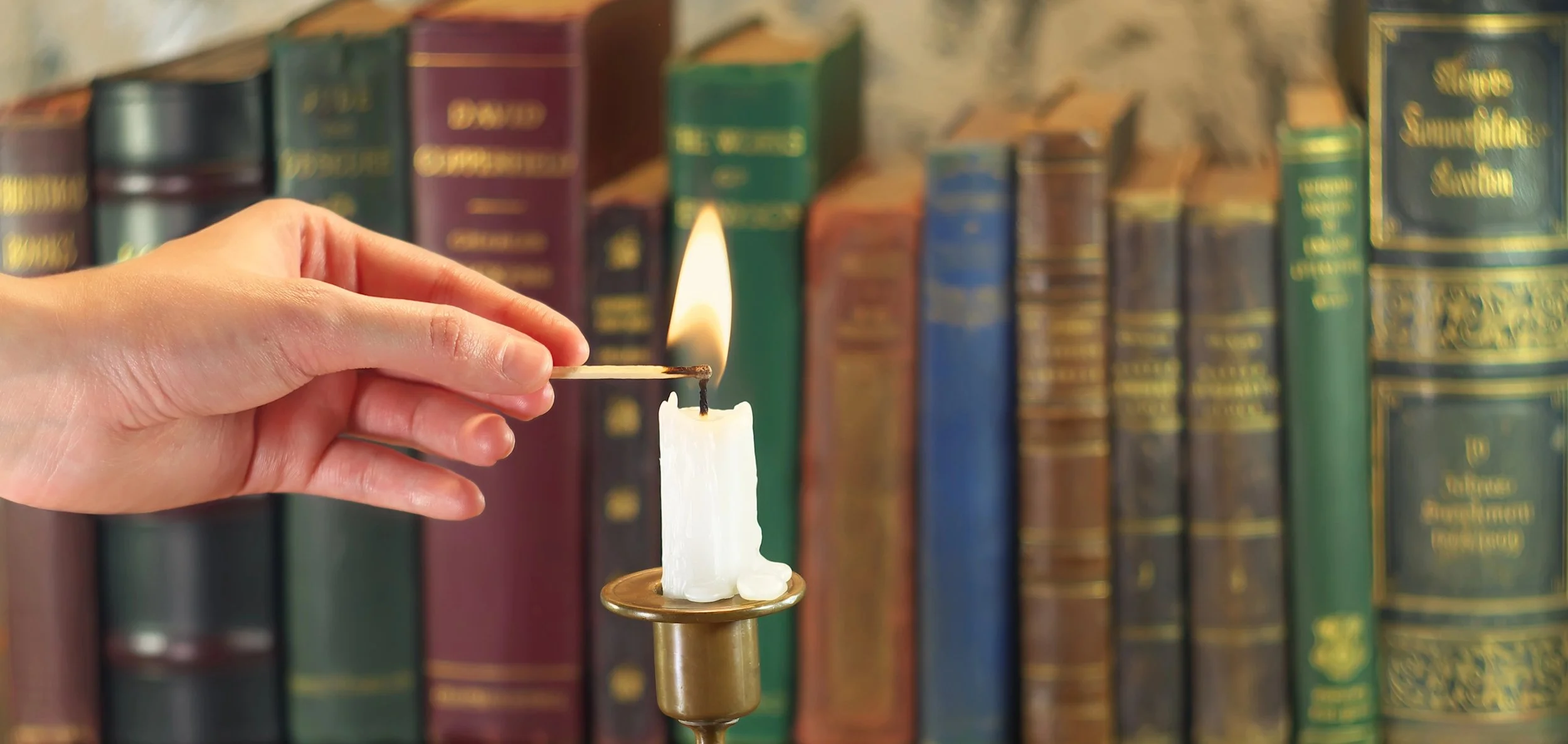 library life and light hand lighting candle books cropped.jpg