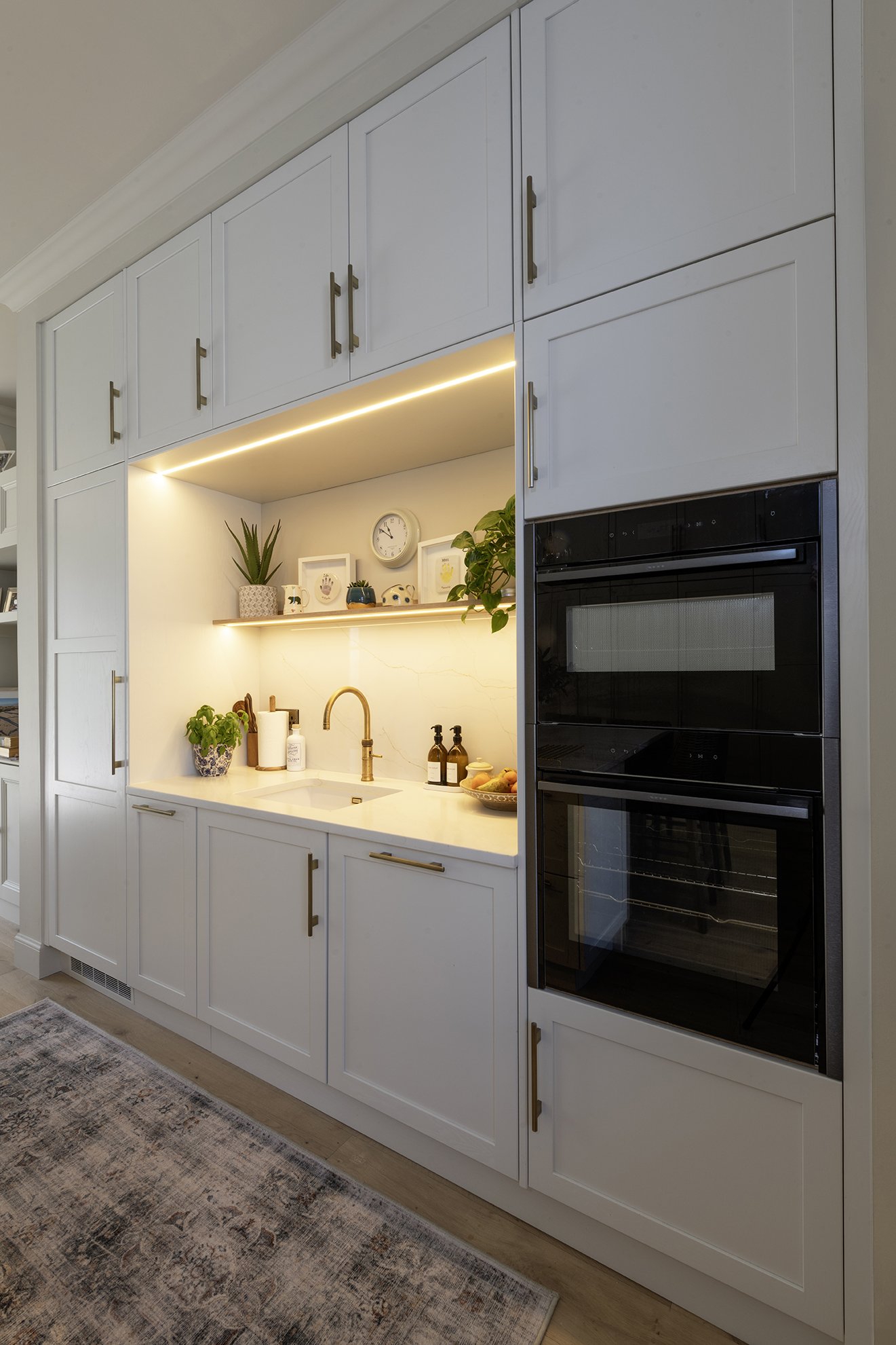 Full height storage walls make best use of the room height and frame the sink.
