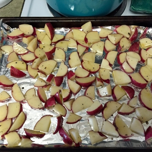 red potatoes with herbs sitting in cookie sheet