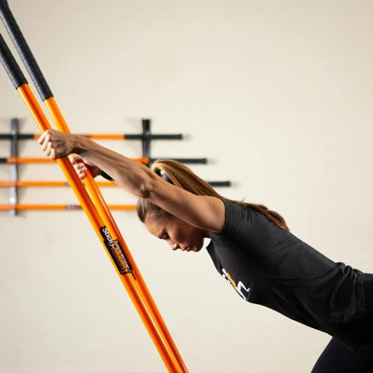 Athlete Performing Lat Stretches Using Mobility Sticks