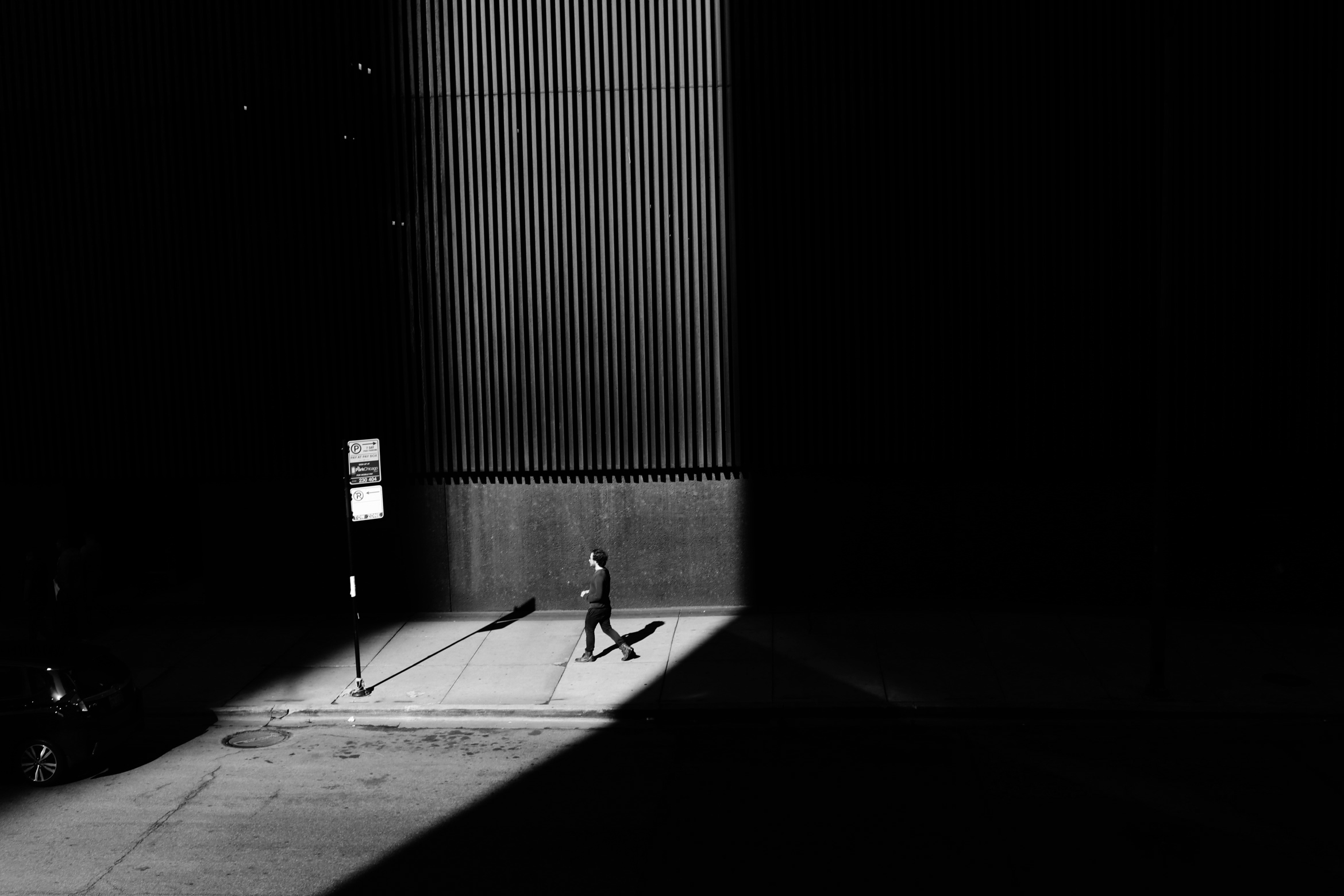 A man walks through a shaft of light on an unseasonably warm day in February 2017 in downtown Chicago. 