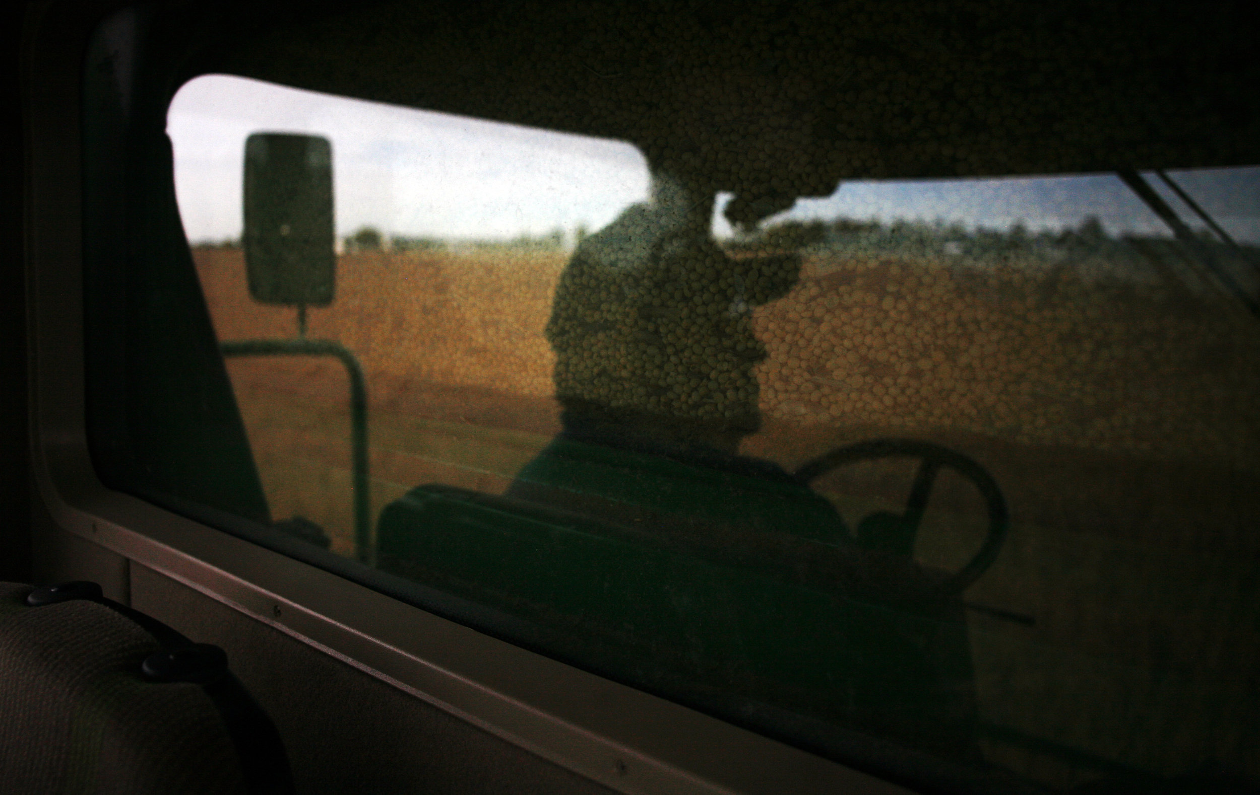 John Motter's reflection is seen in his combine while he harvests his soybean fields in Hancock County, OH. 