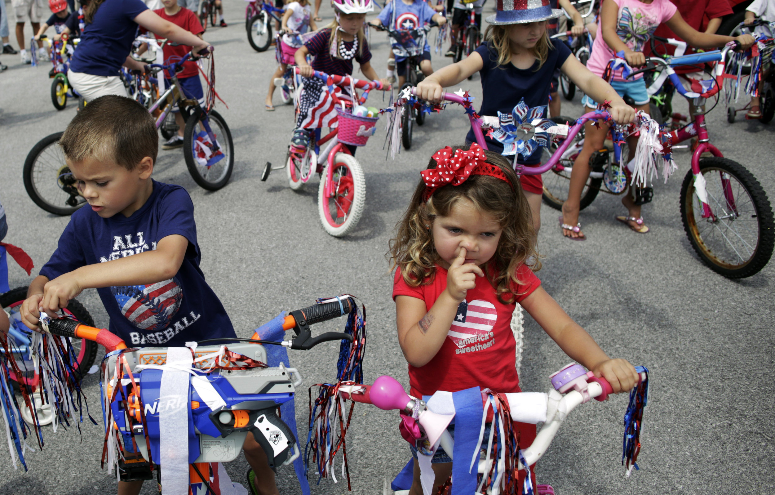 A girl is caught picking her nose before the start of the Fourth of July Bike Parade in Pemberville, Ohio. The kids spent the morning decorating their bikes in red, white and blue before going for a ride around town, which ended with Popsicles and juice boxes.