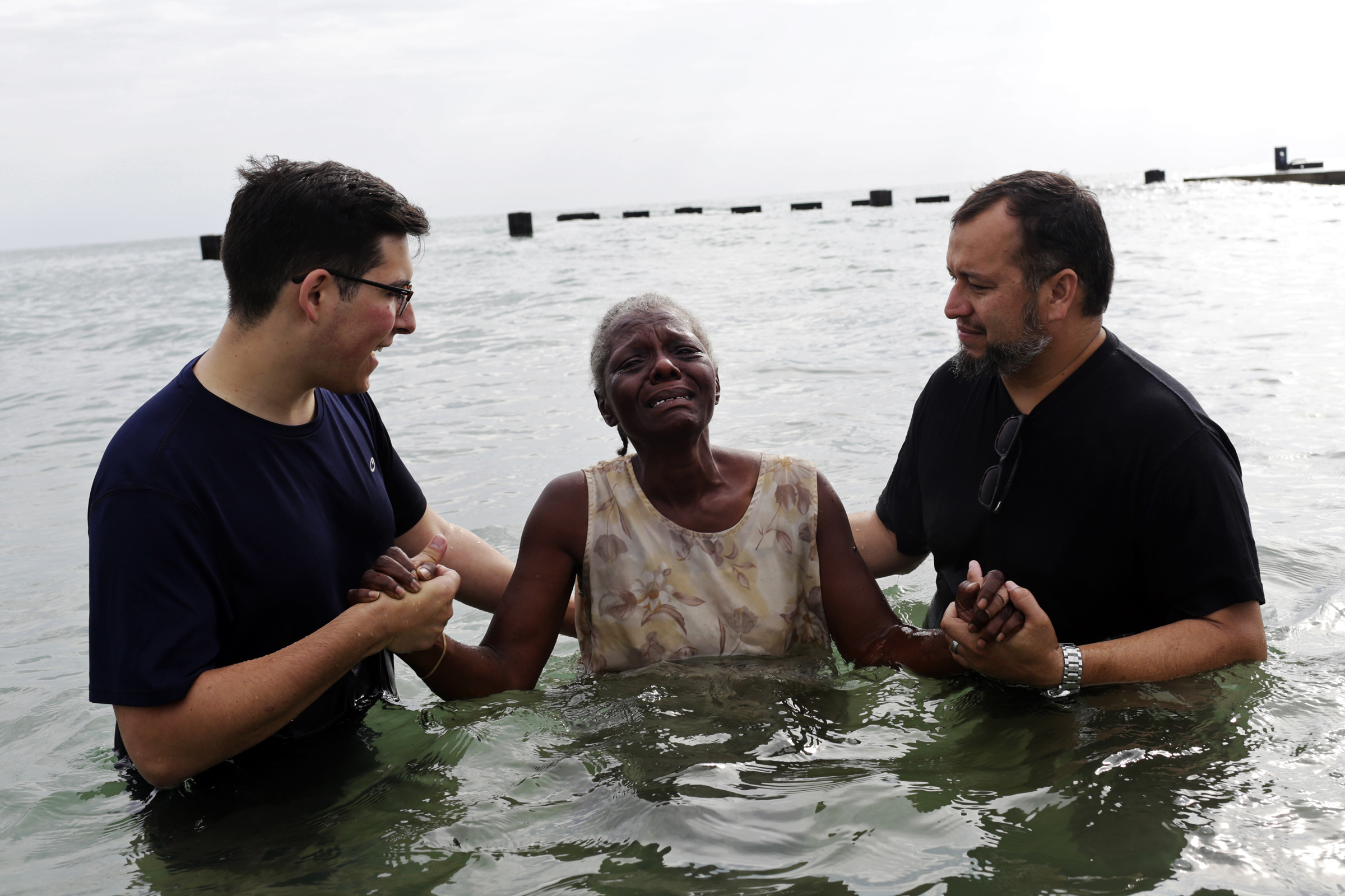 A woman named Valarie becomes emotional as she is about to be baptized by being submerged in Lake Michigan near North Ave. Beach by members of the Moody Baptist Church on August 27, 2017 in Chicago. 