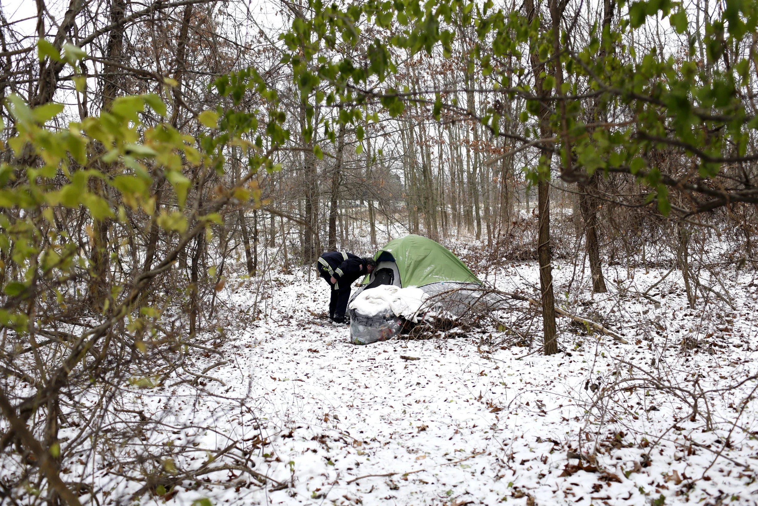  Michael Waldron, Fire Captain of the GR Homeless Outreach Team, is seen inspecting a tent in November 2023 in the woods next to Oak Grove Cemetery in Grand Rapids, MI. The woods are a popular place for unhouse people to stay, where they are less lik